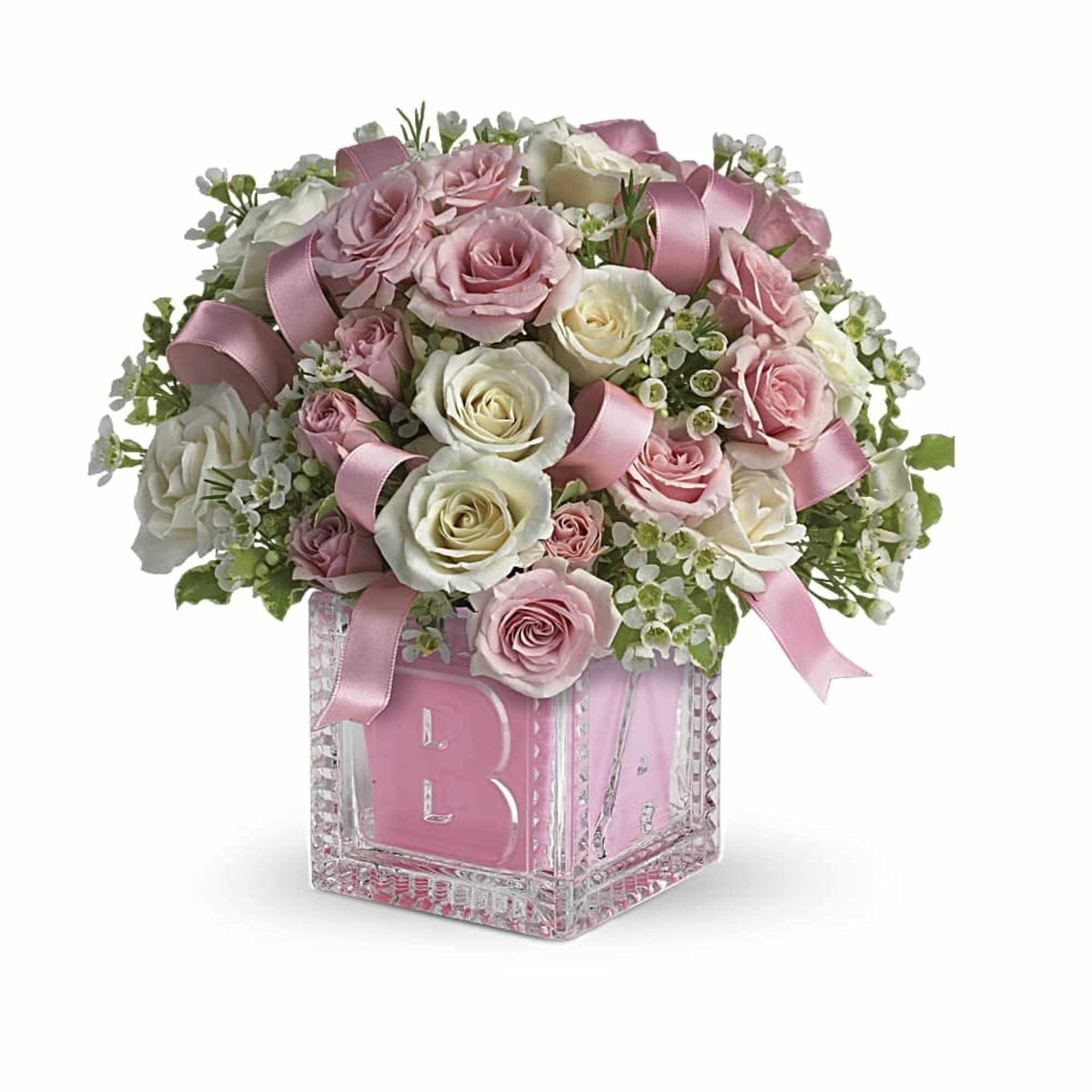 Pink and white rose arrangement in a glass block vase with ribbon