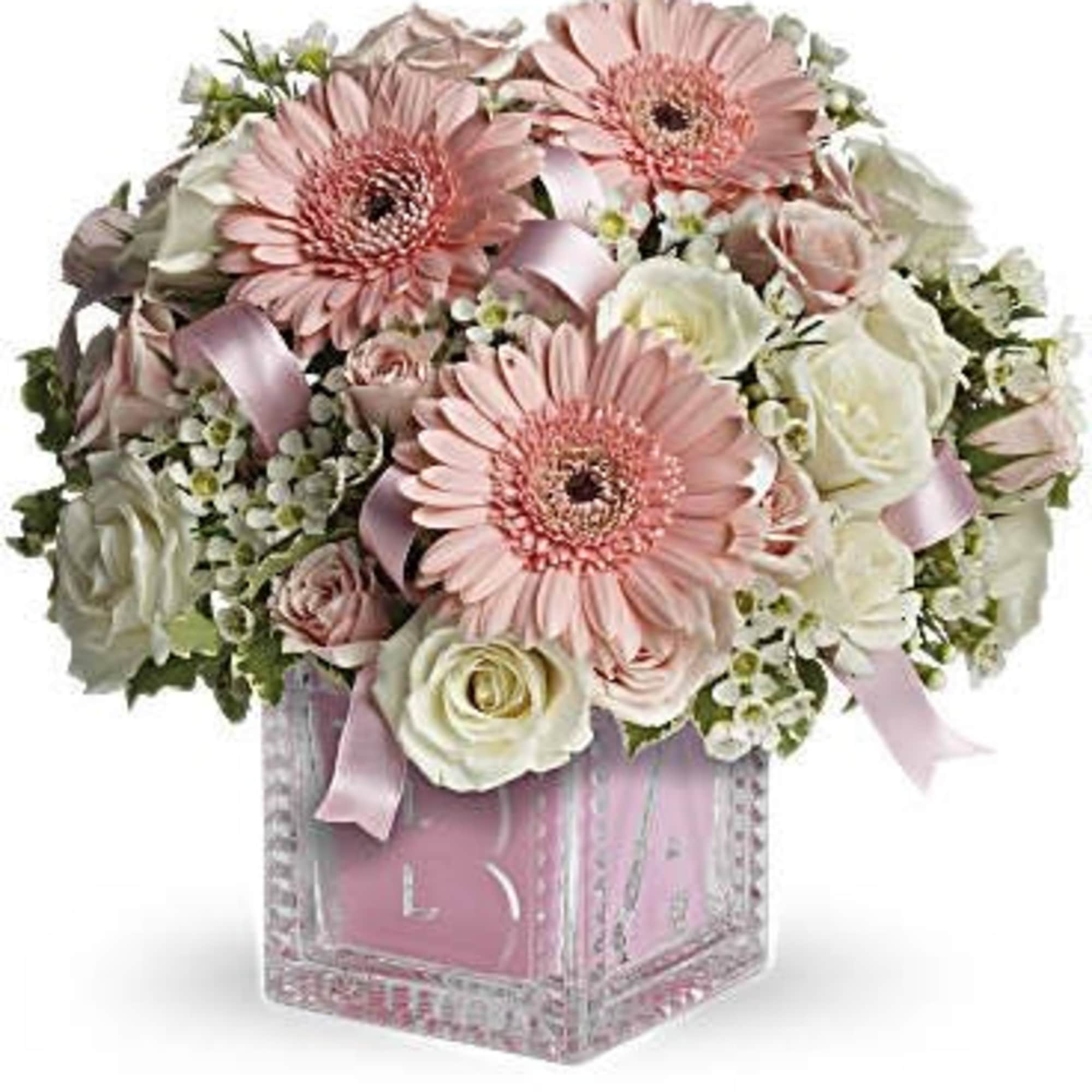 Pink gerbera daisies and white roses in a clear square vase with pink ribbon
