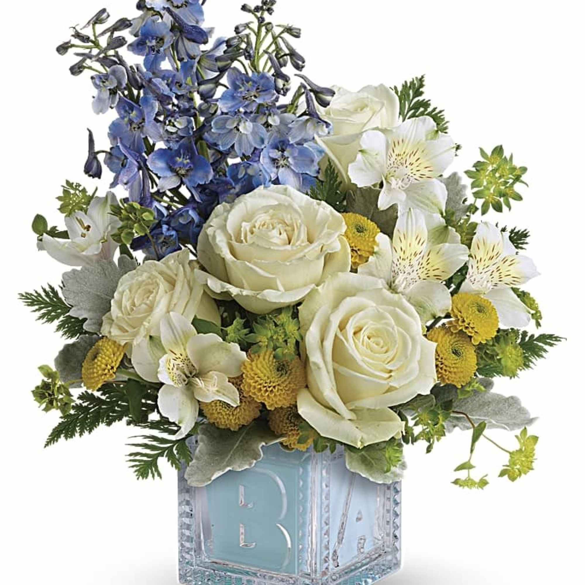 White roses and blue flowers arranged in a glass cube vase