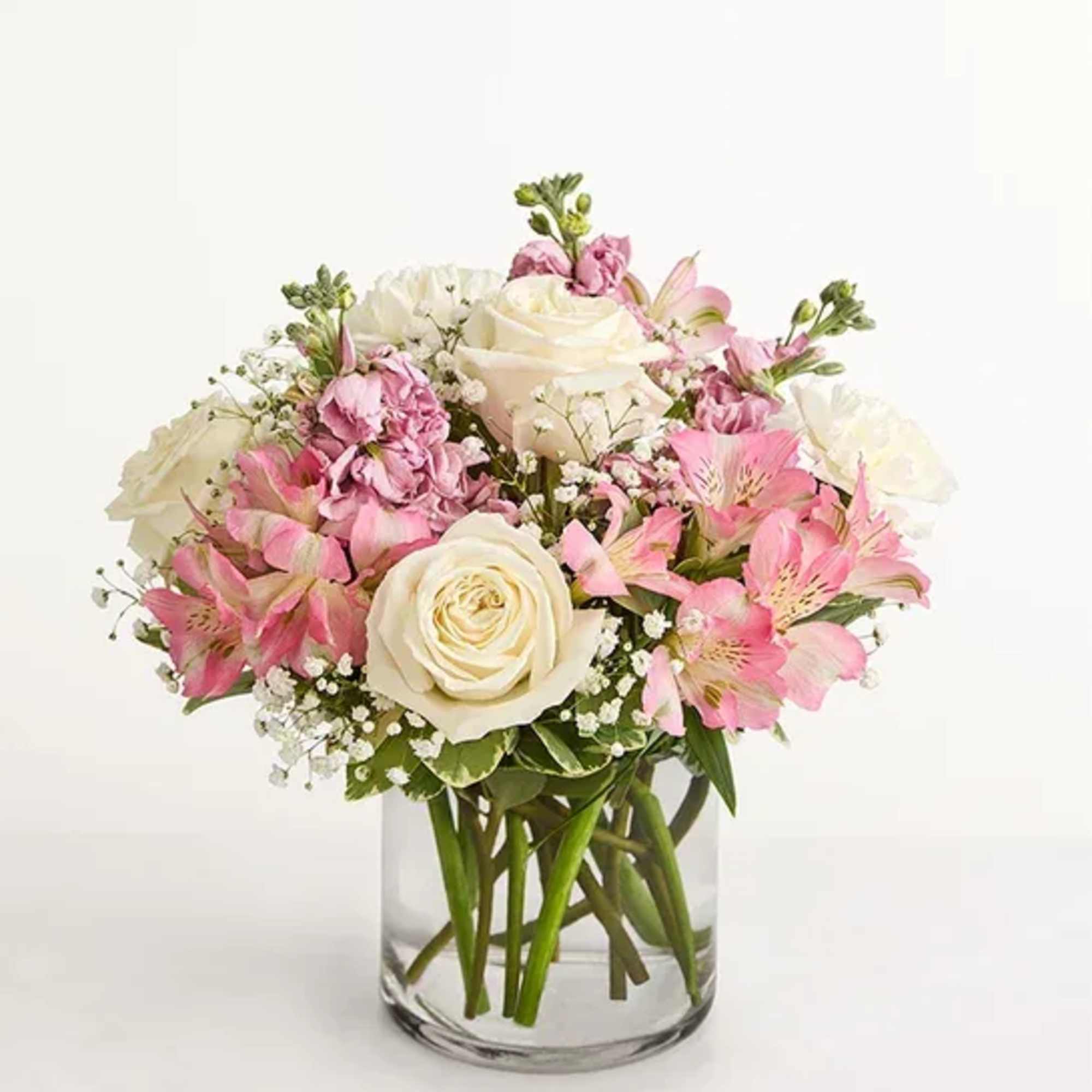 Pink and white bouquet of roses and lilies in a clear glass vase