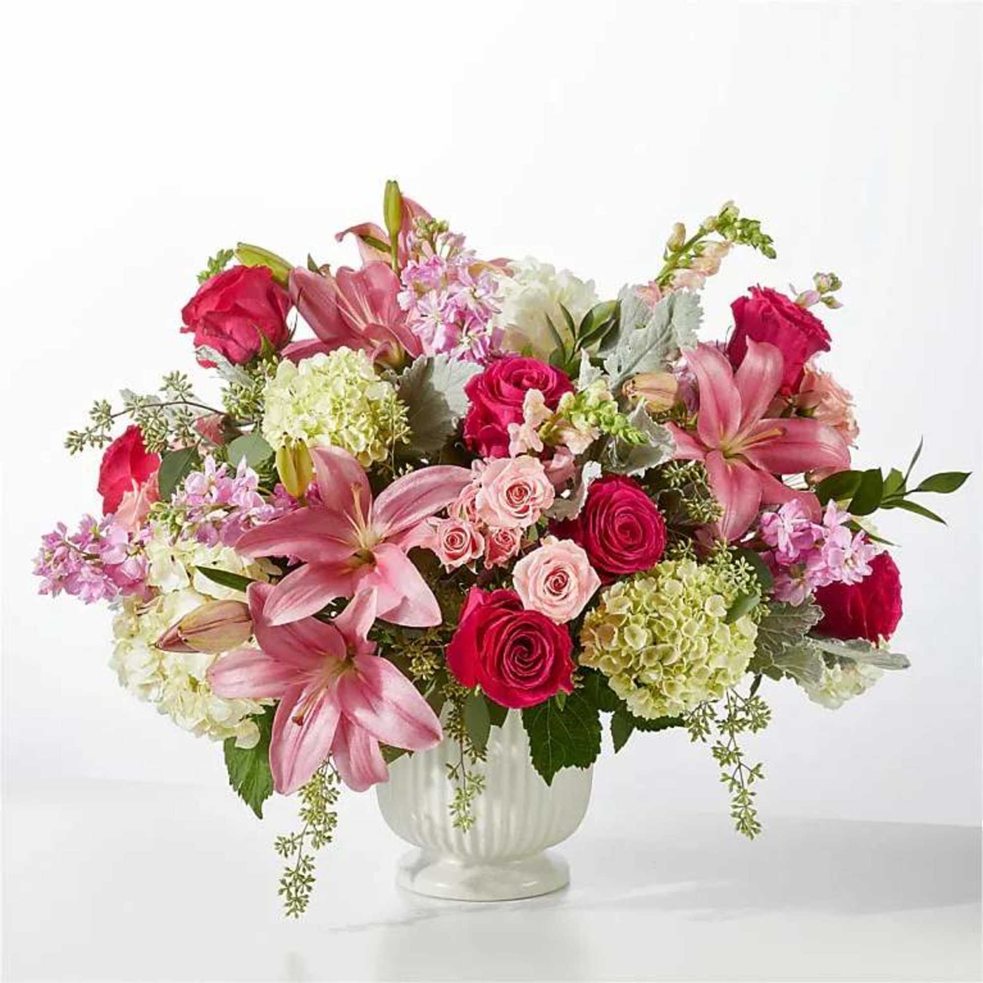 Pink lilies and roses in a white vase