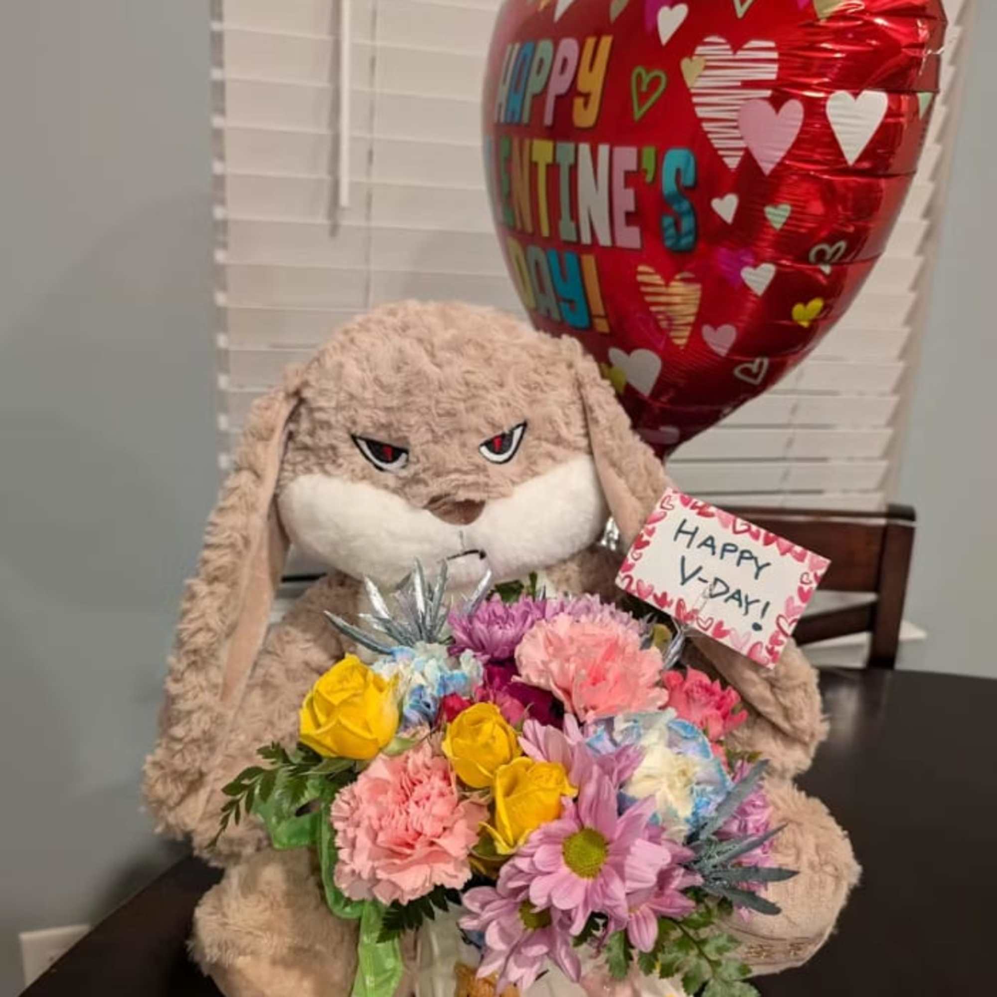 Plush bunny holding a bouquet with a Valentine balloon and card