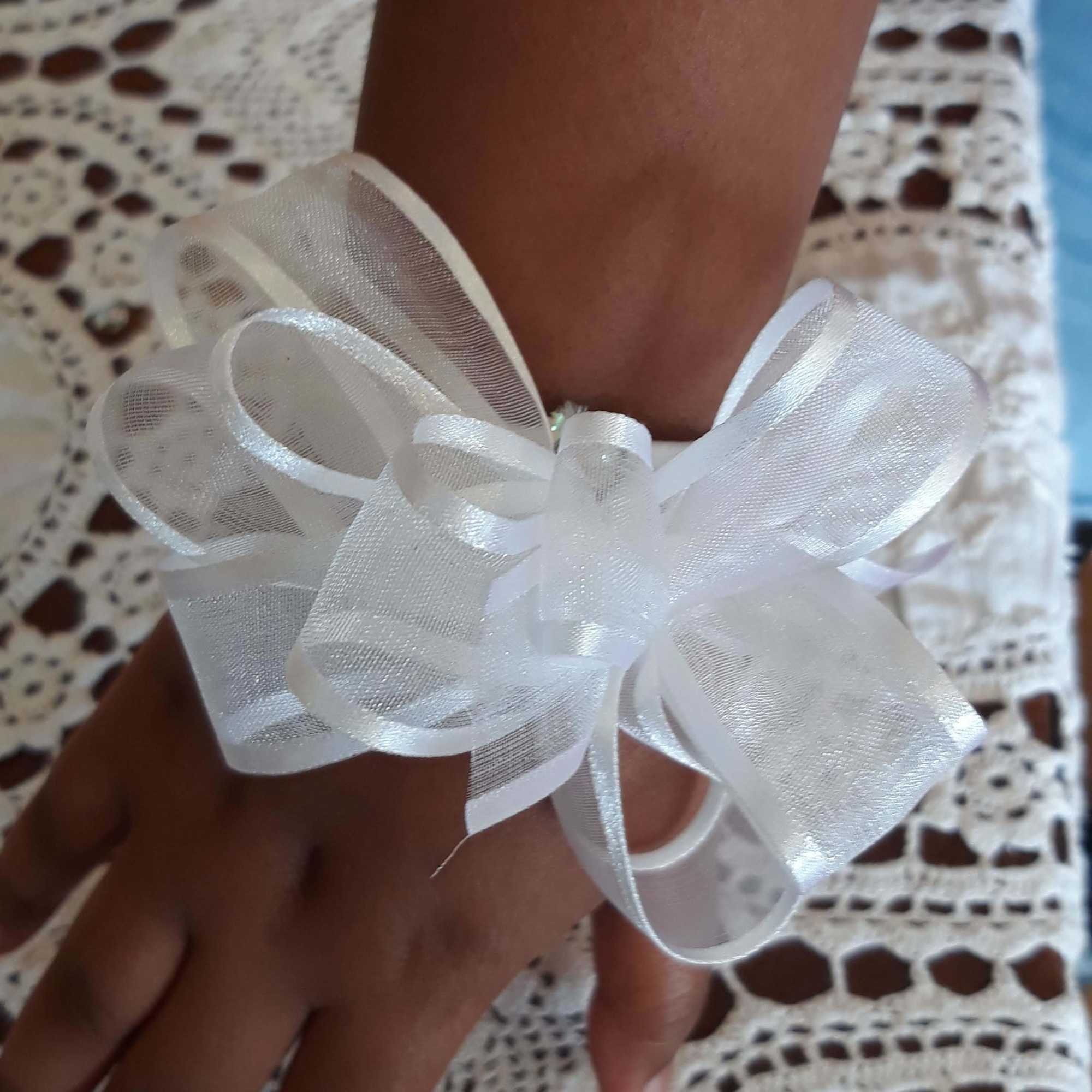 White ribbon bow tied around a wrist