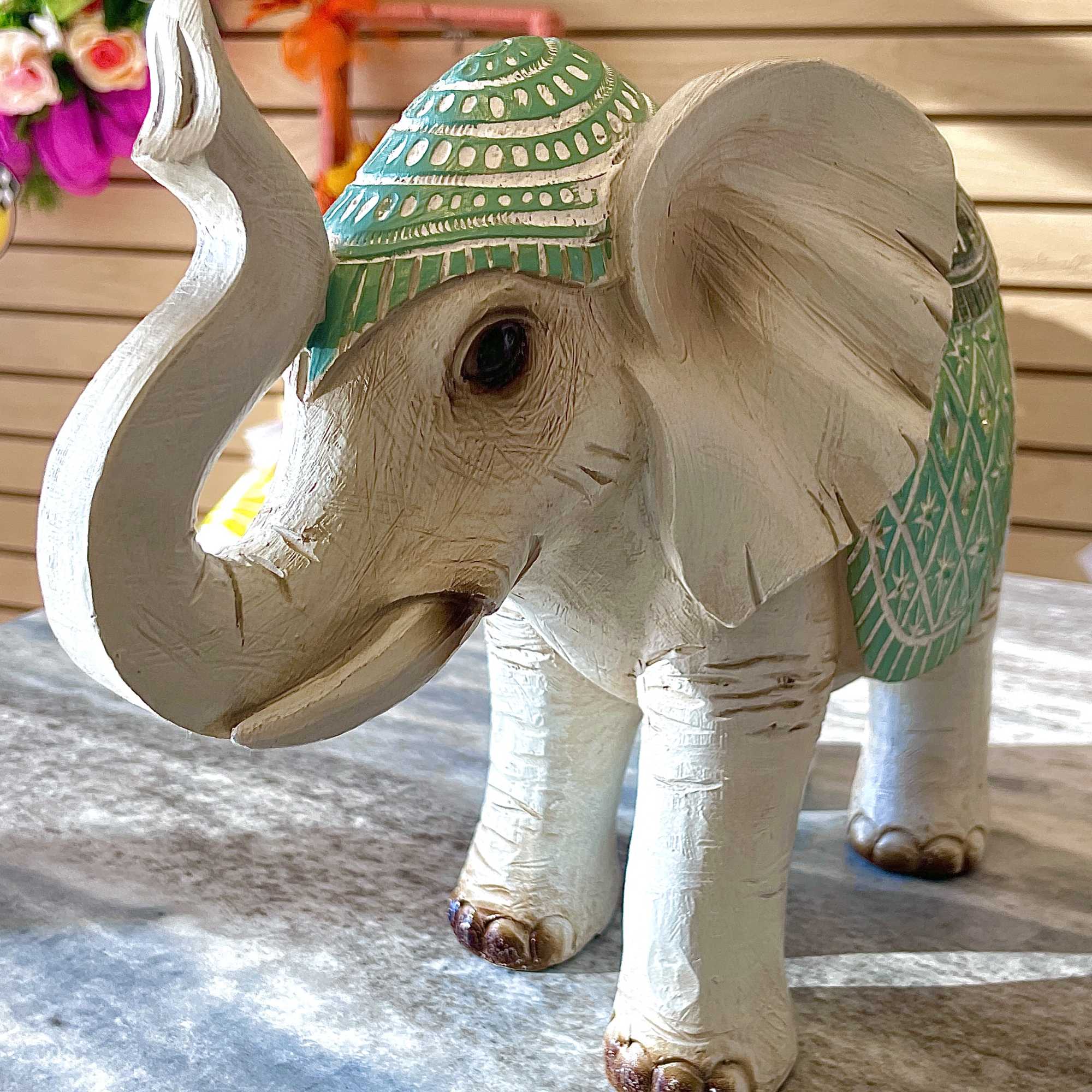 Decorative carved elephant figurine with green painted accents