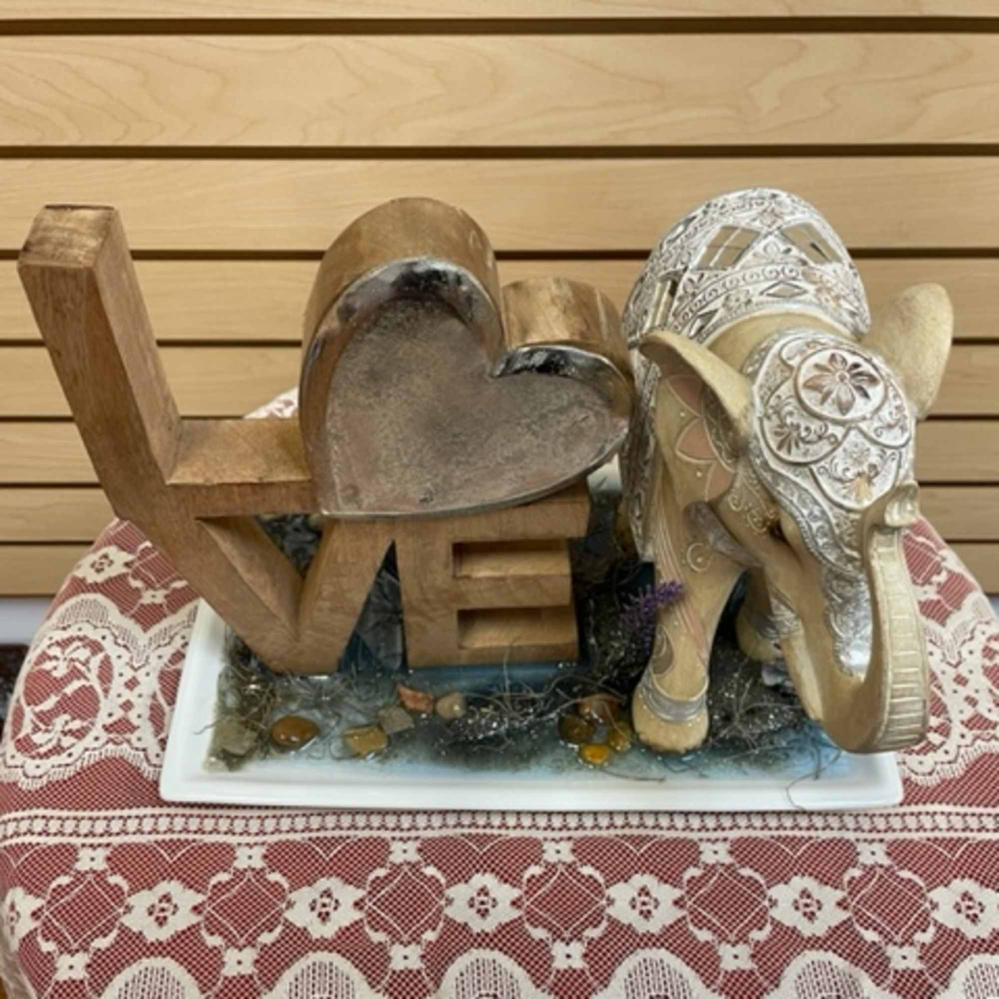 Wooden LOVE sign with a decorative elephant figurine on a tray