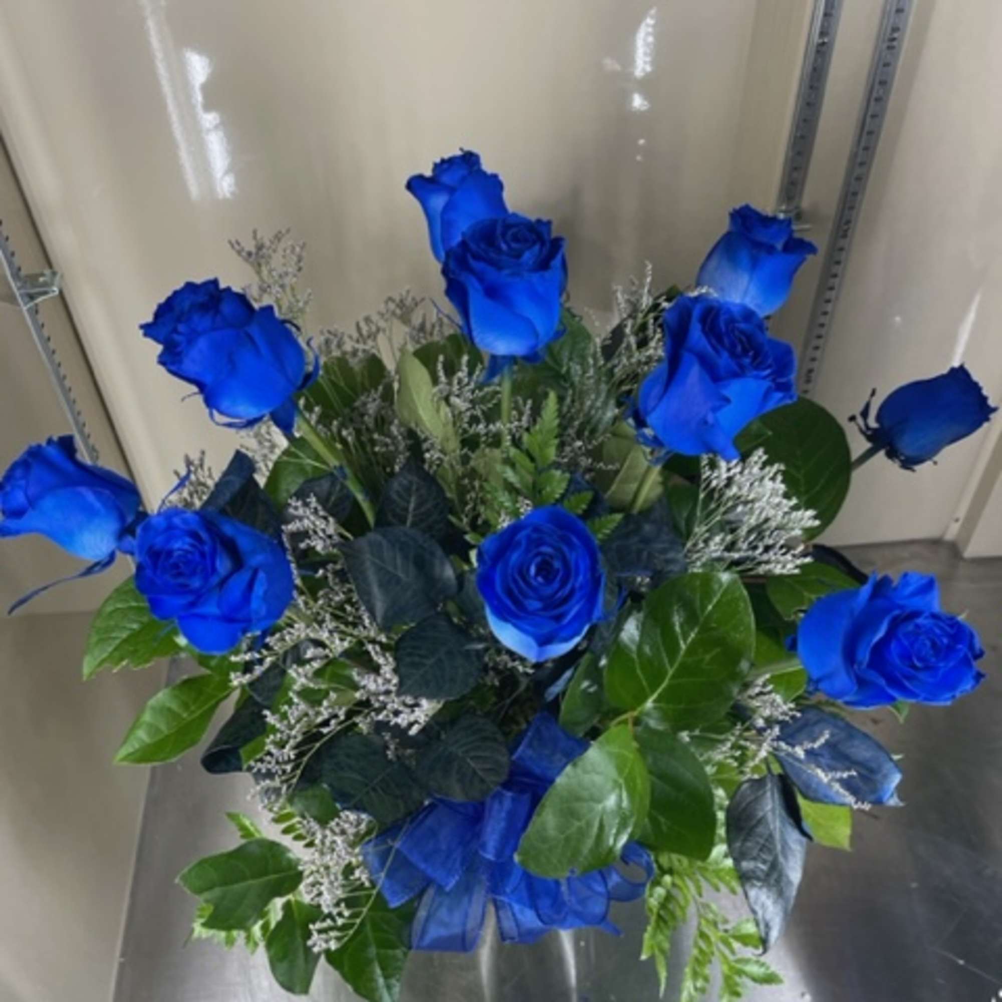 12 dyed blue roses in vase with misty blue accent
