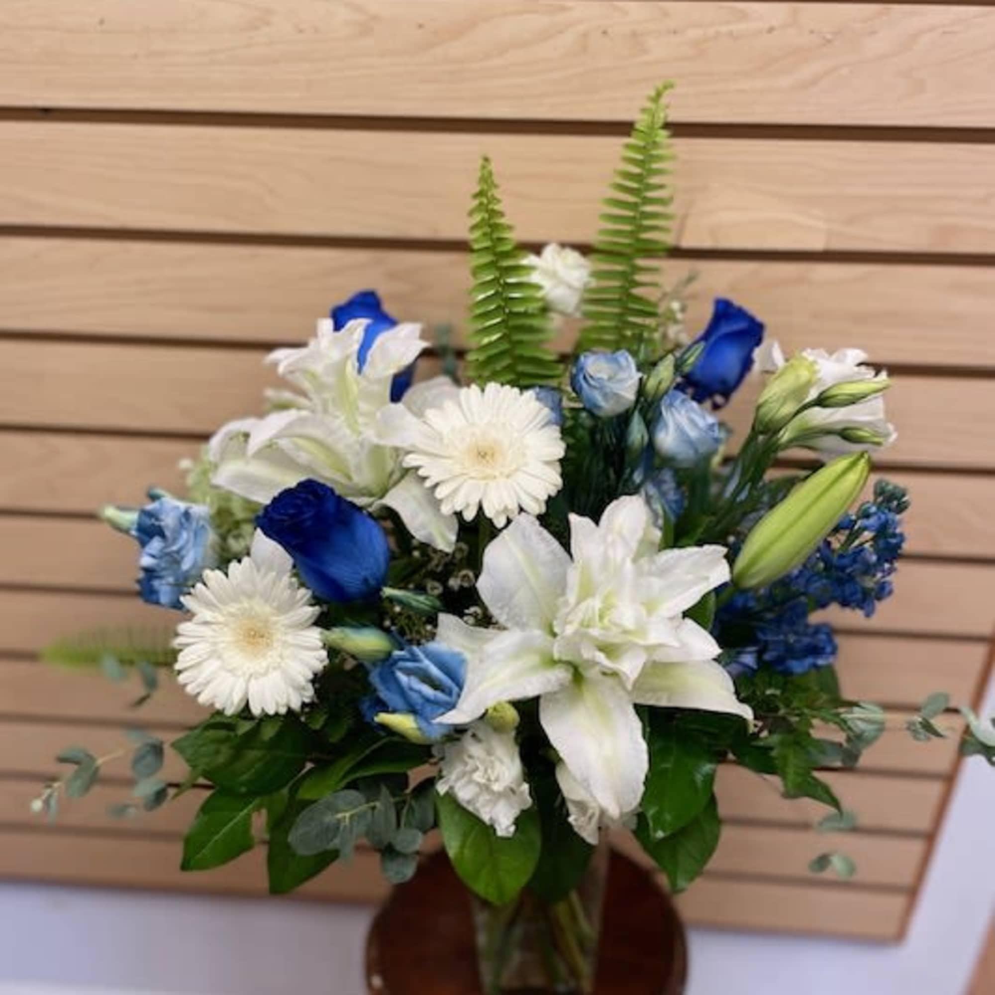 Blue and white flower arrangement in a glass vase