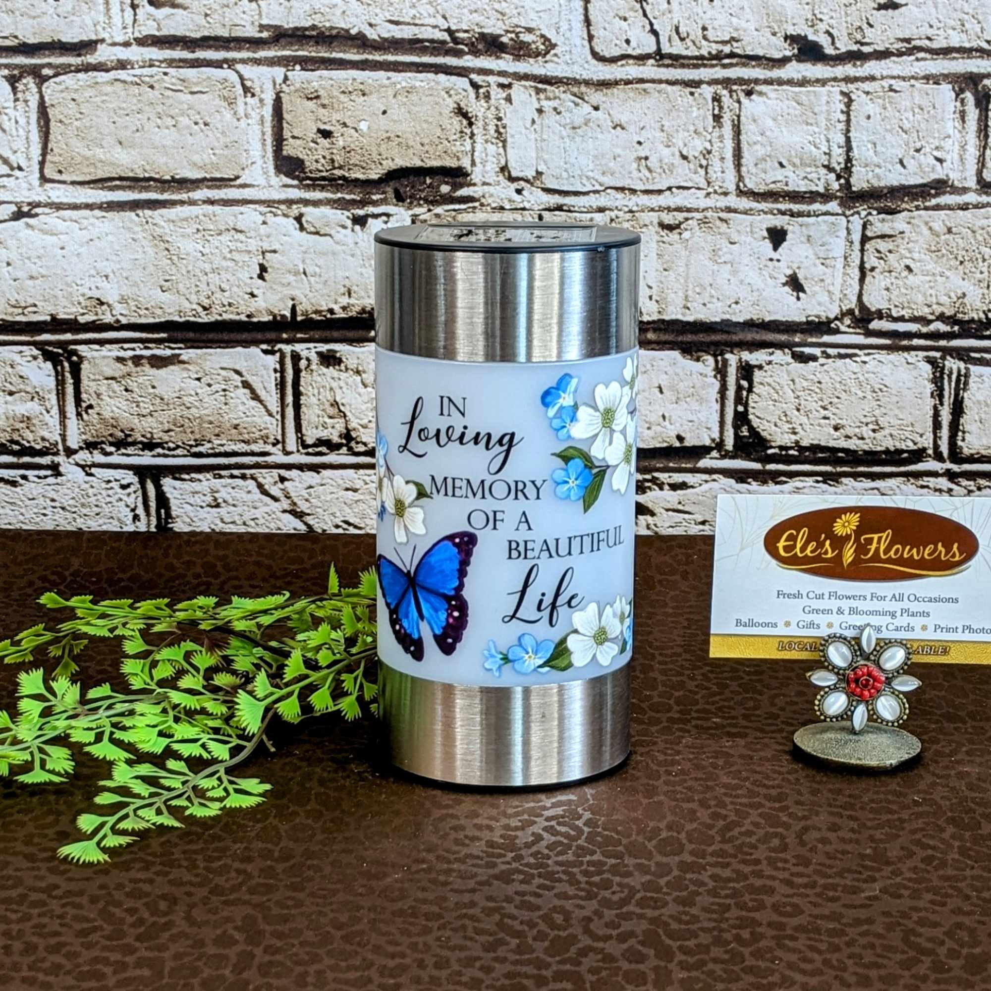 Memorial candle in a silver metal holder with floral and butterfly design