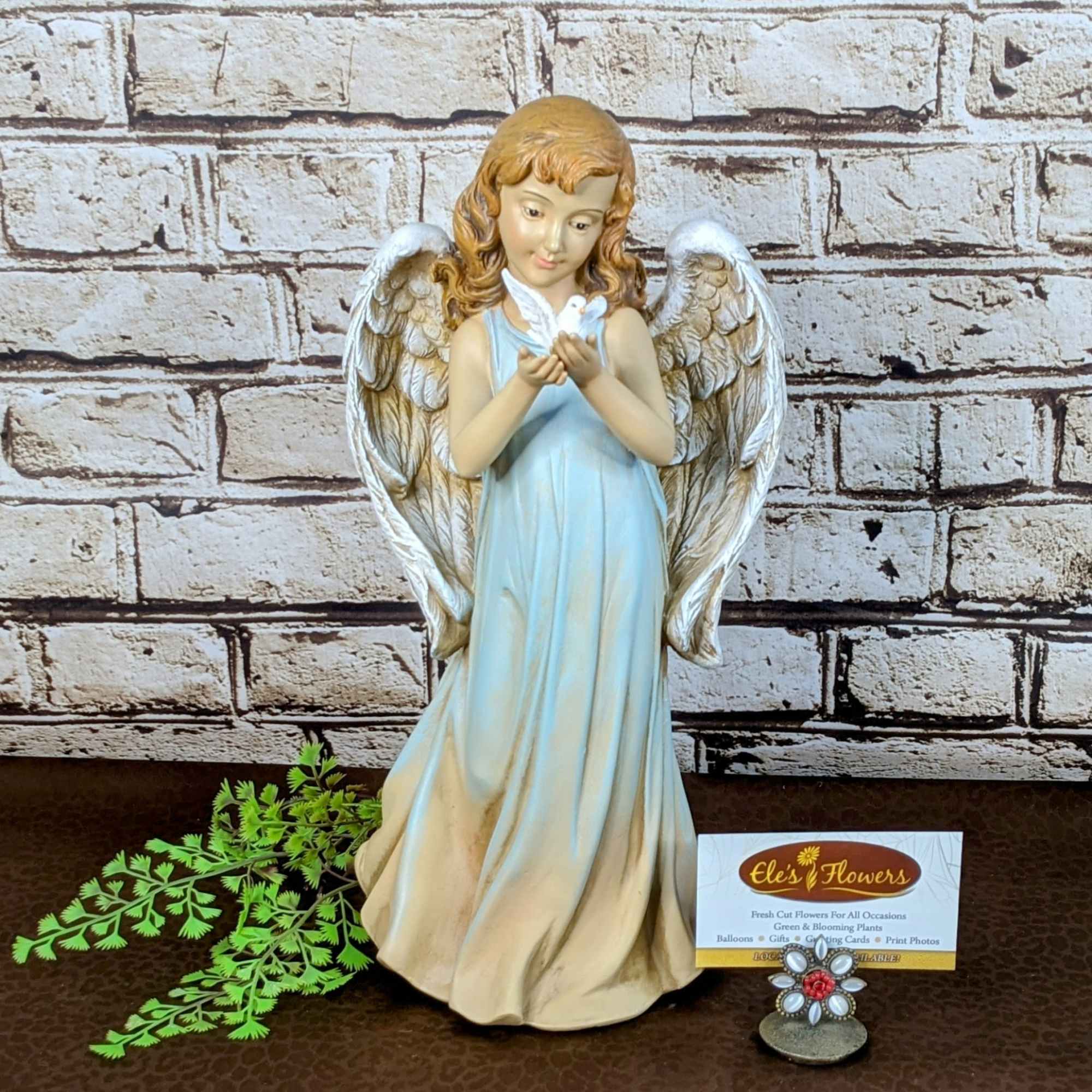 Angel figurine in a blue dress holding a white dove
