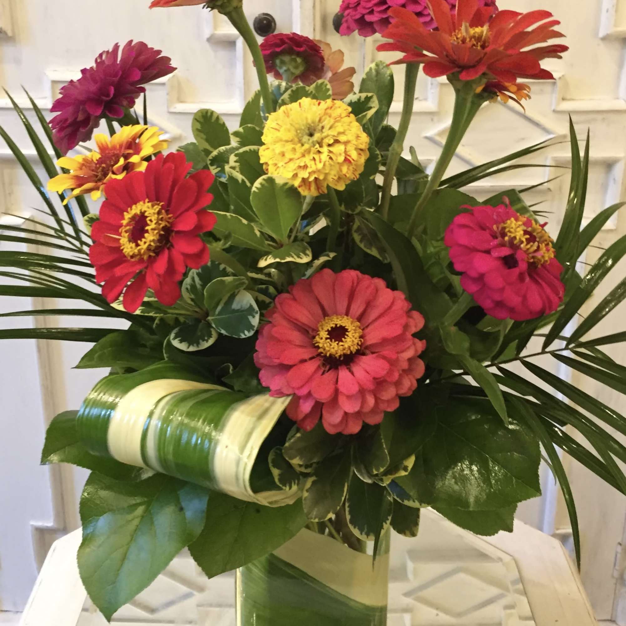 Bright mixed zinnia bouquet in a clear glass vase