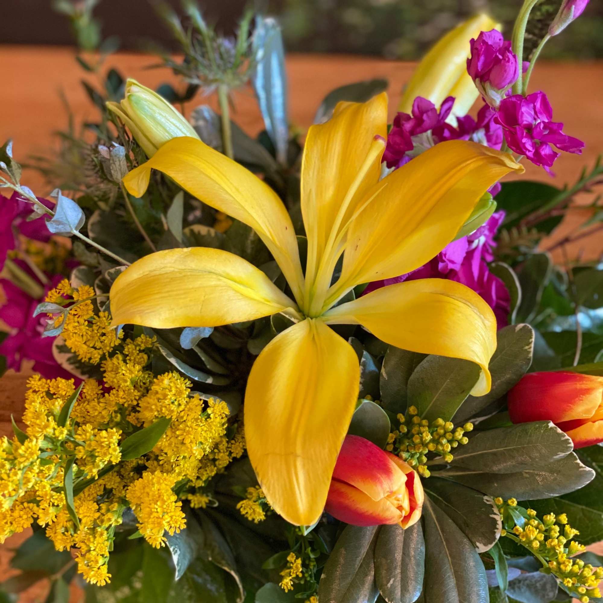 Bouquet with yellow lilies, red tulips, and purple flowers