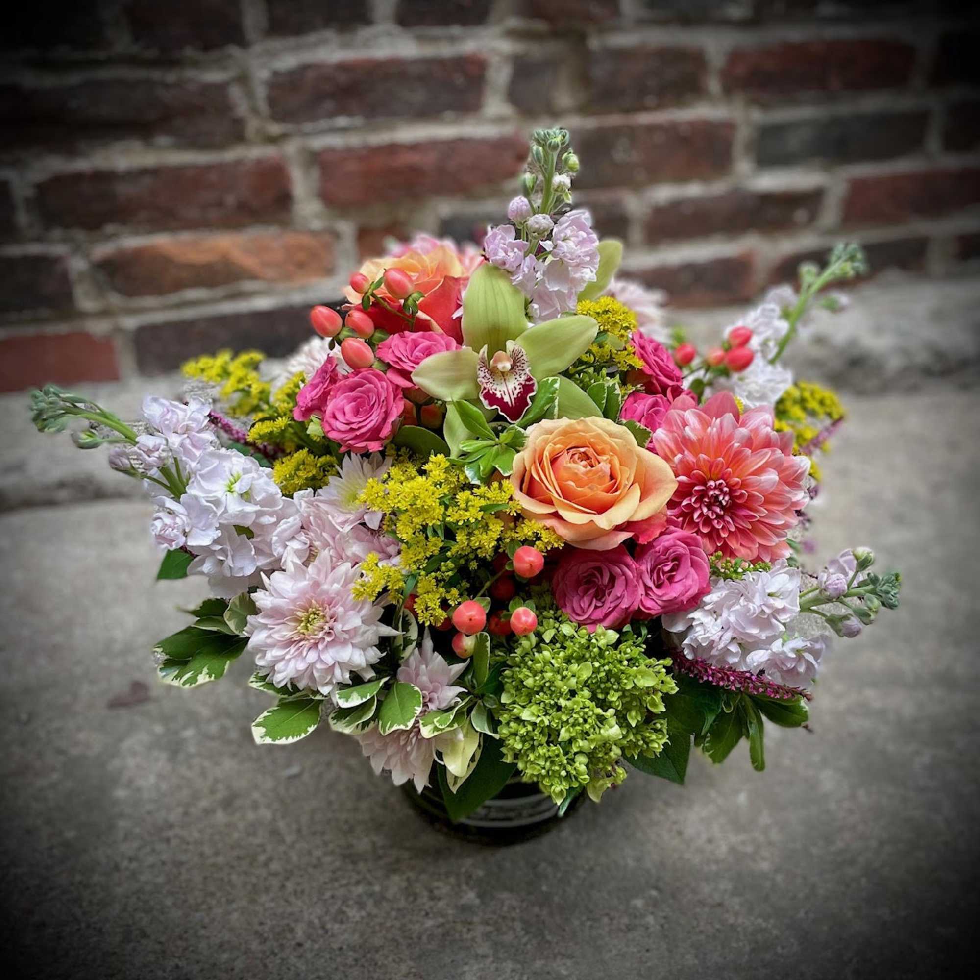 Mixed bouquet with pink, peach, and white flowers in a low container