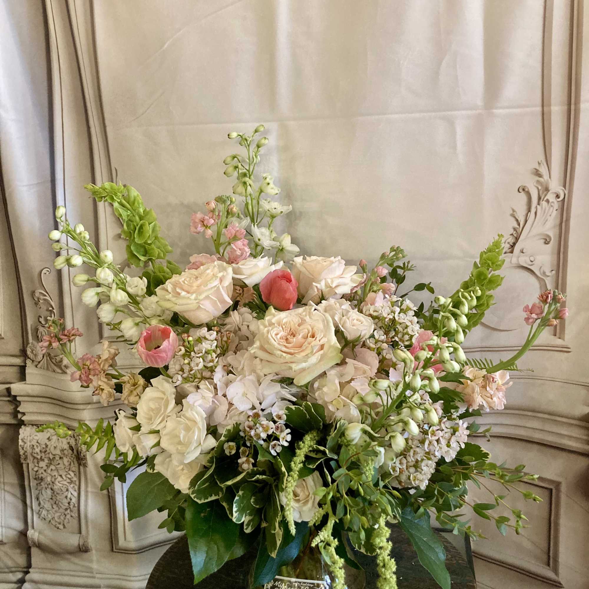 Soft blush roses and airy garden blooms create a delicate, romantic statement-perfect
