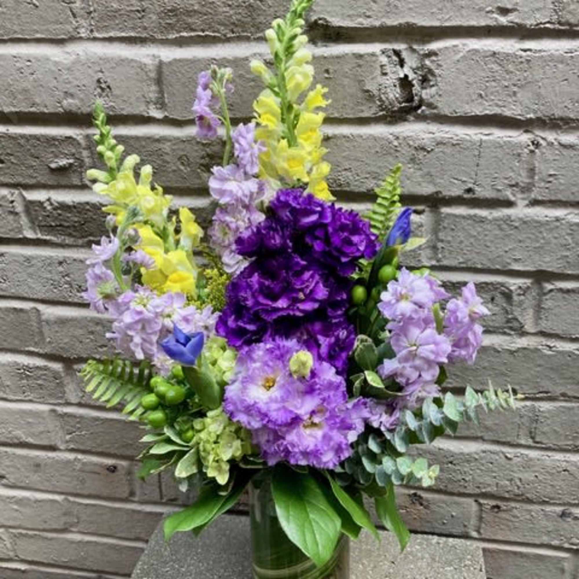 Tall lavender and purple blooms mingle with sunny yellow accents in this