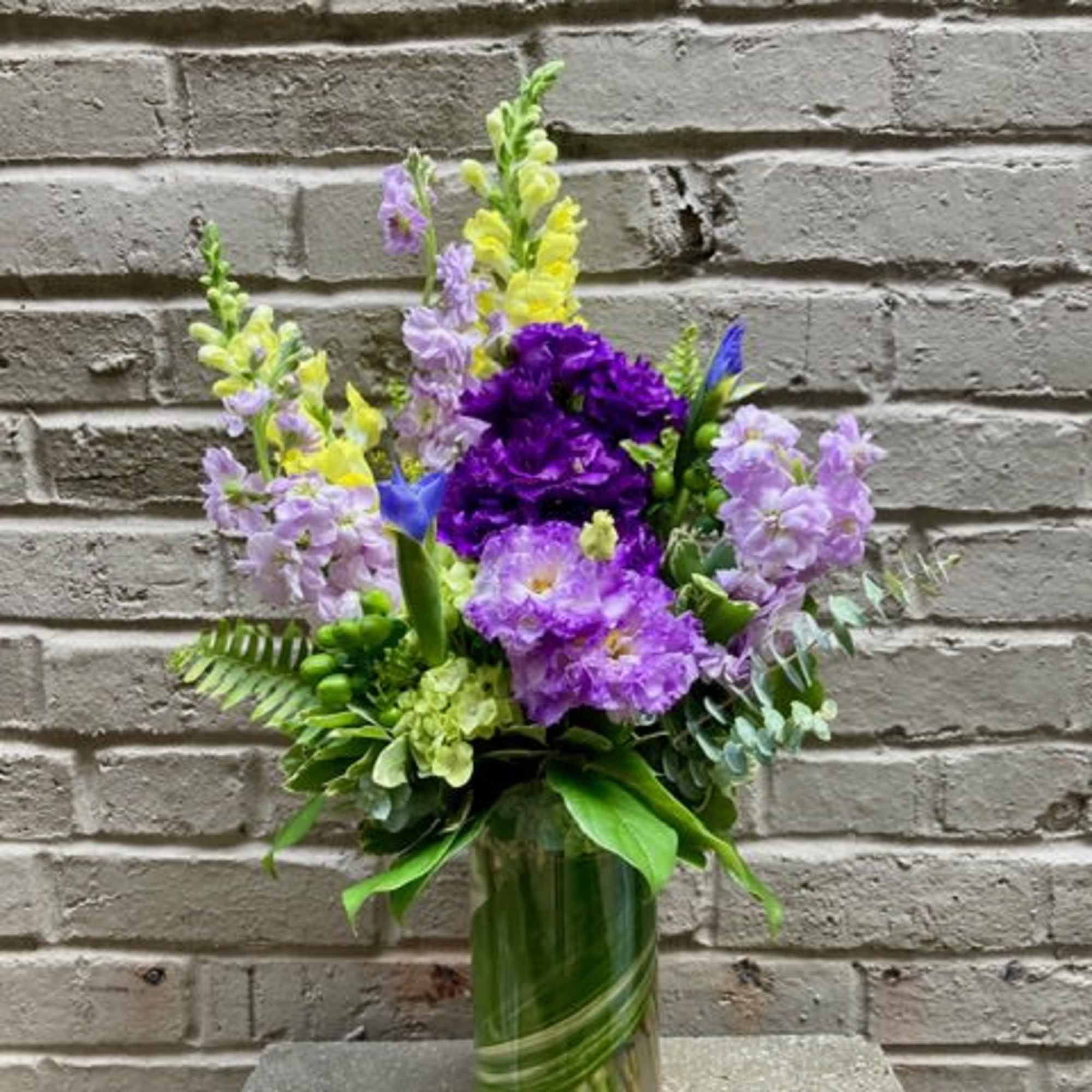 Tall lavender and purple blooms mingle with sunny yellow accents in this