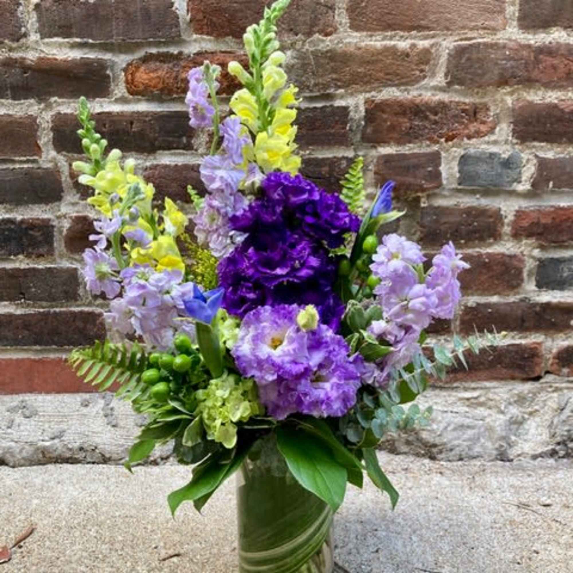 Tall lavender and purple blooms mingle with sunny yellow accents in this
