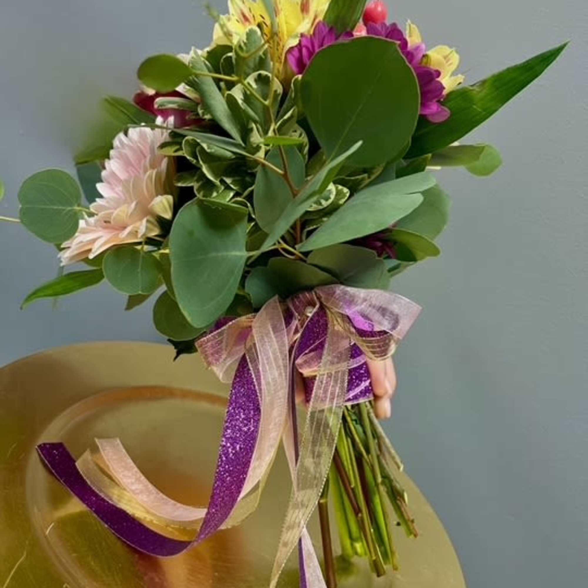 Hand-tied bouquet of mixed flowers with purple ribbon