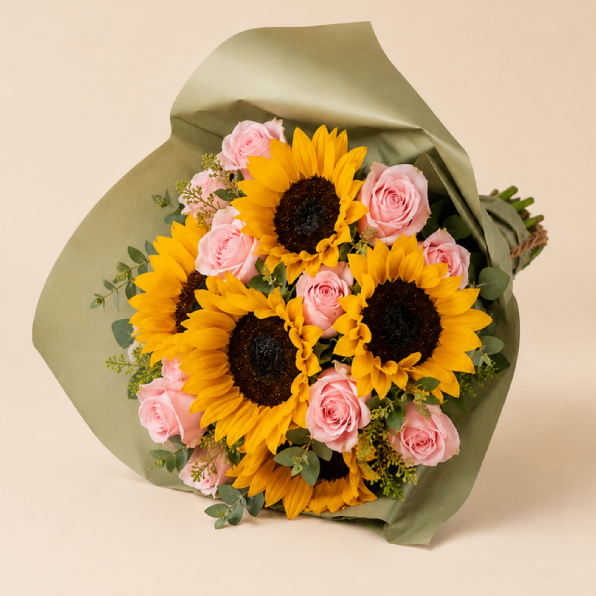 Bouquet of yellow sunflowers and pink roses wrapped in green paper
