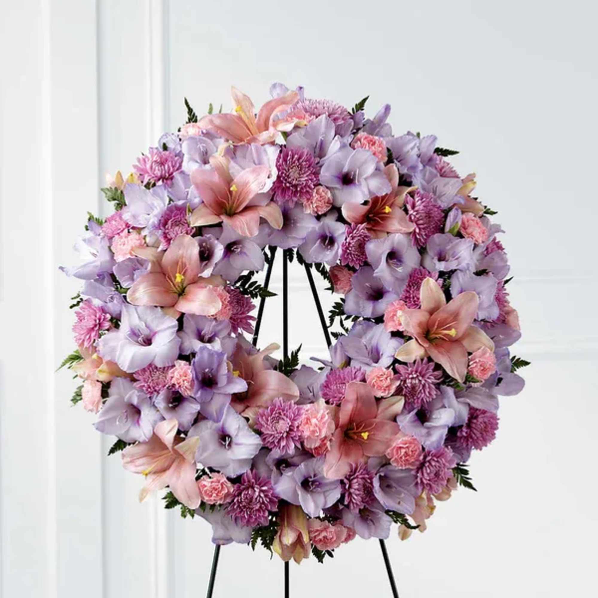 Lavender and pink floral wreath on a black stand