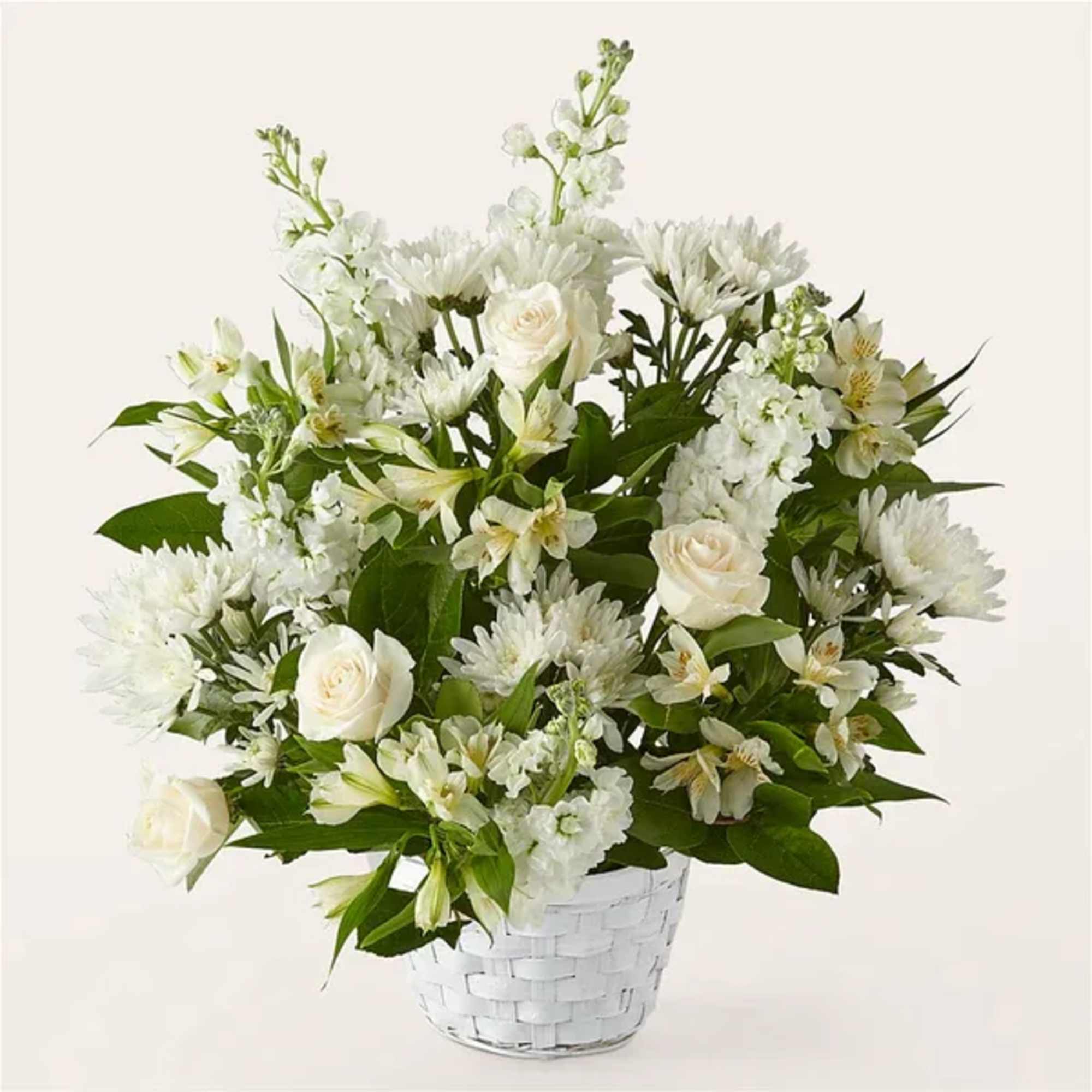 White floral arrangement in a white woven basket