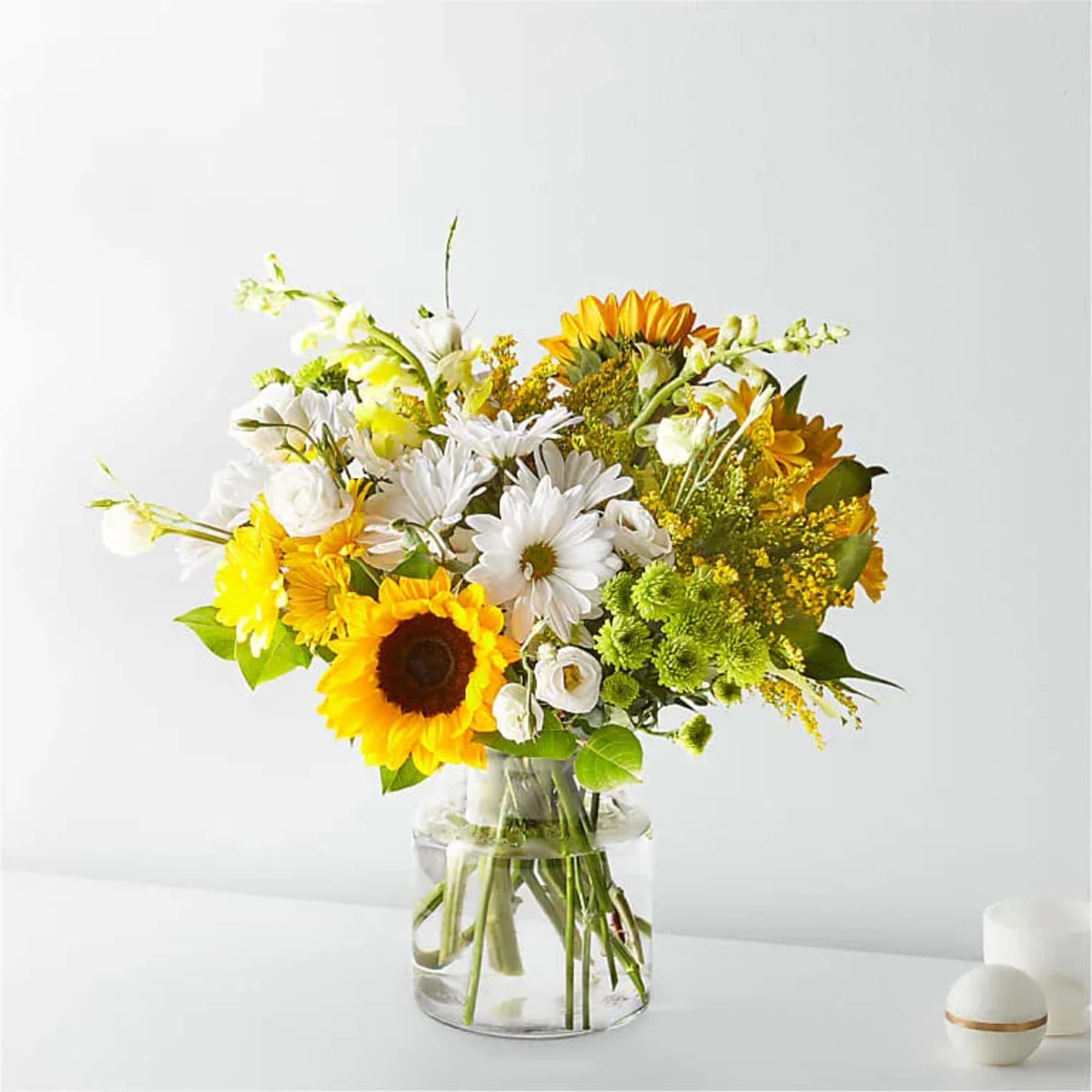 Bouquet of yellow and white flowers in a clear glass vase
