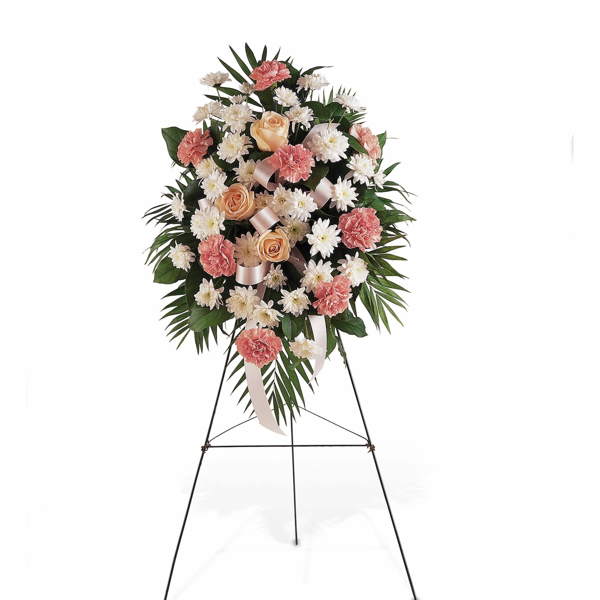 Standing spray of peach roses, pink carnations, and white daisies on a metal easel.