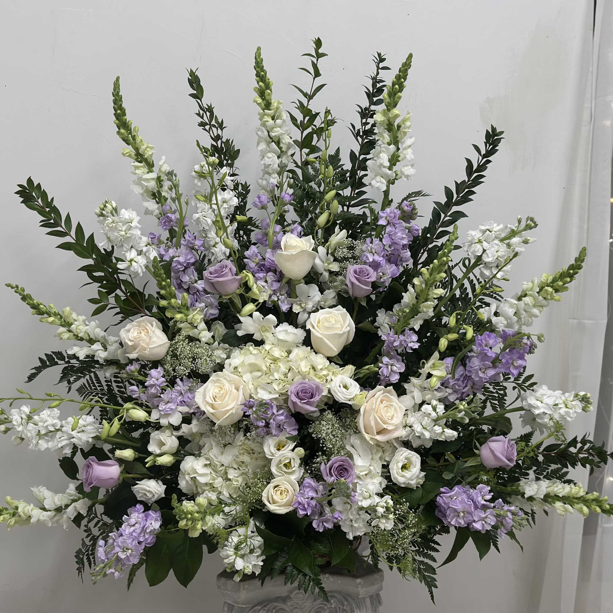 Large lavender and white floral arrangement in a vase