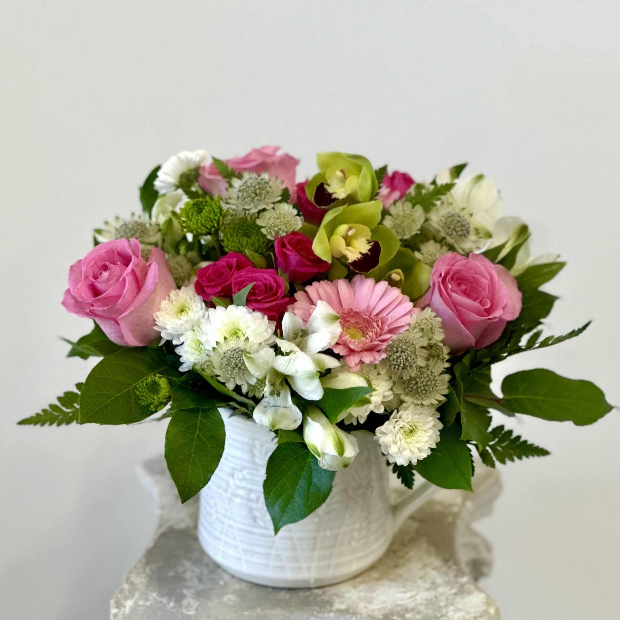 Pink and white mixed flower arrangement in a white vase