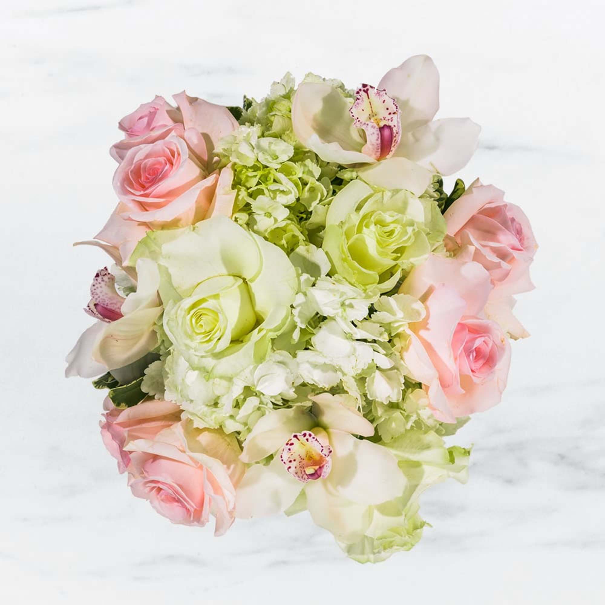 Bouquet of pink roses, pale green hydrangeas, and white orchids
