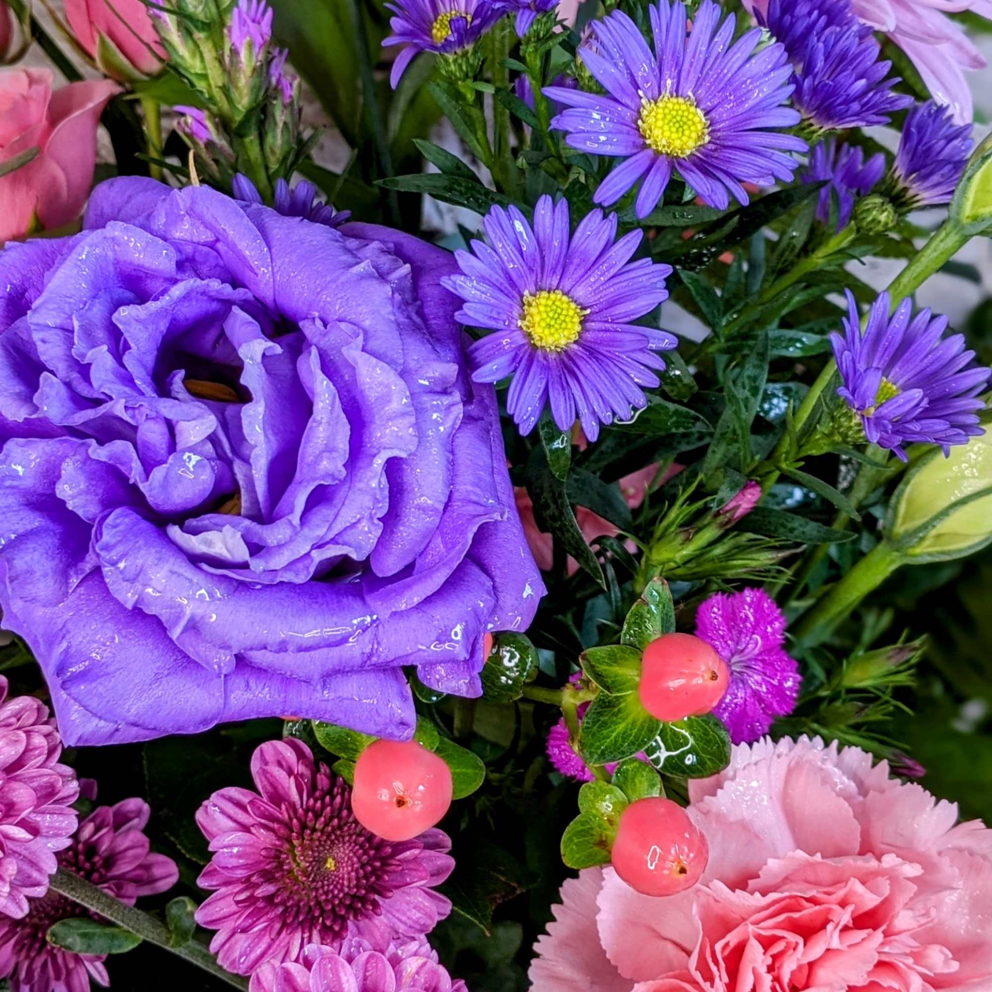 Purple and pink mixed bouquet with chrysanthemums, carnations, and small daisy flowers