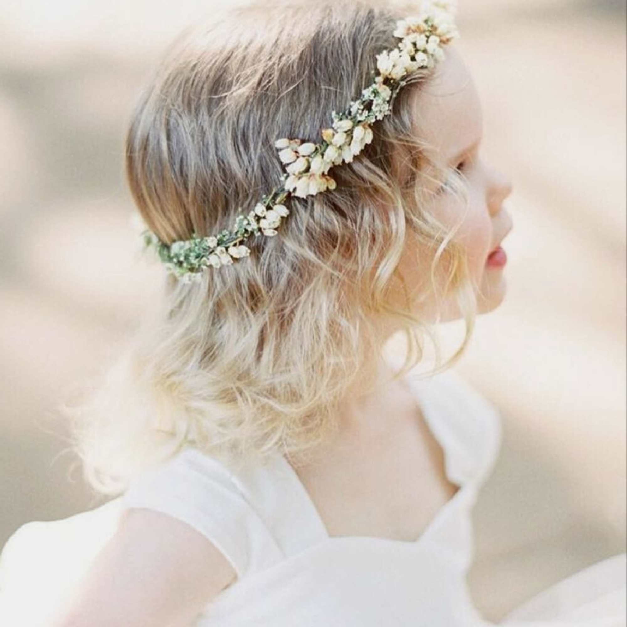 Child wearing a floral crown with small white flowers