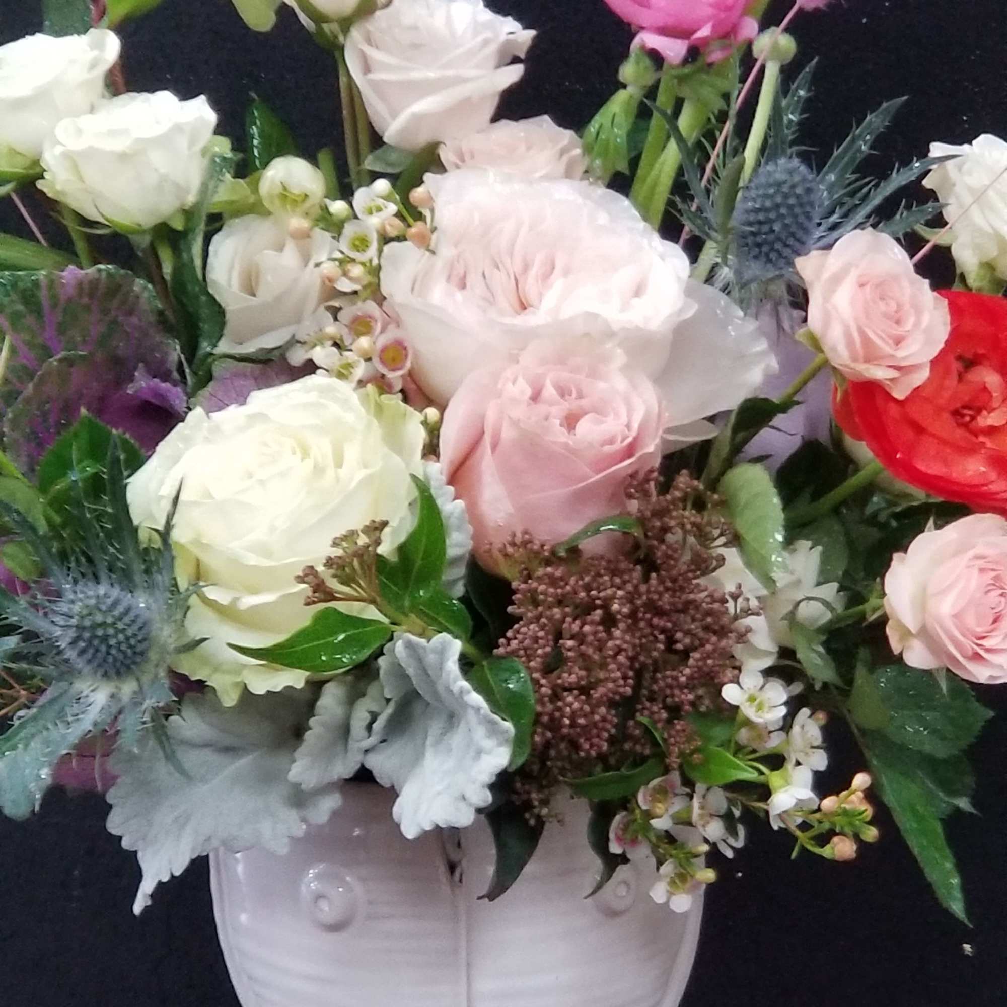 Mixed bouquet of pink and white roses in a white vase