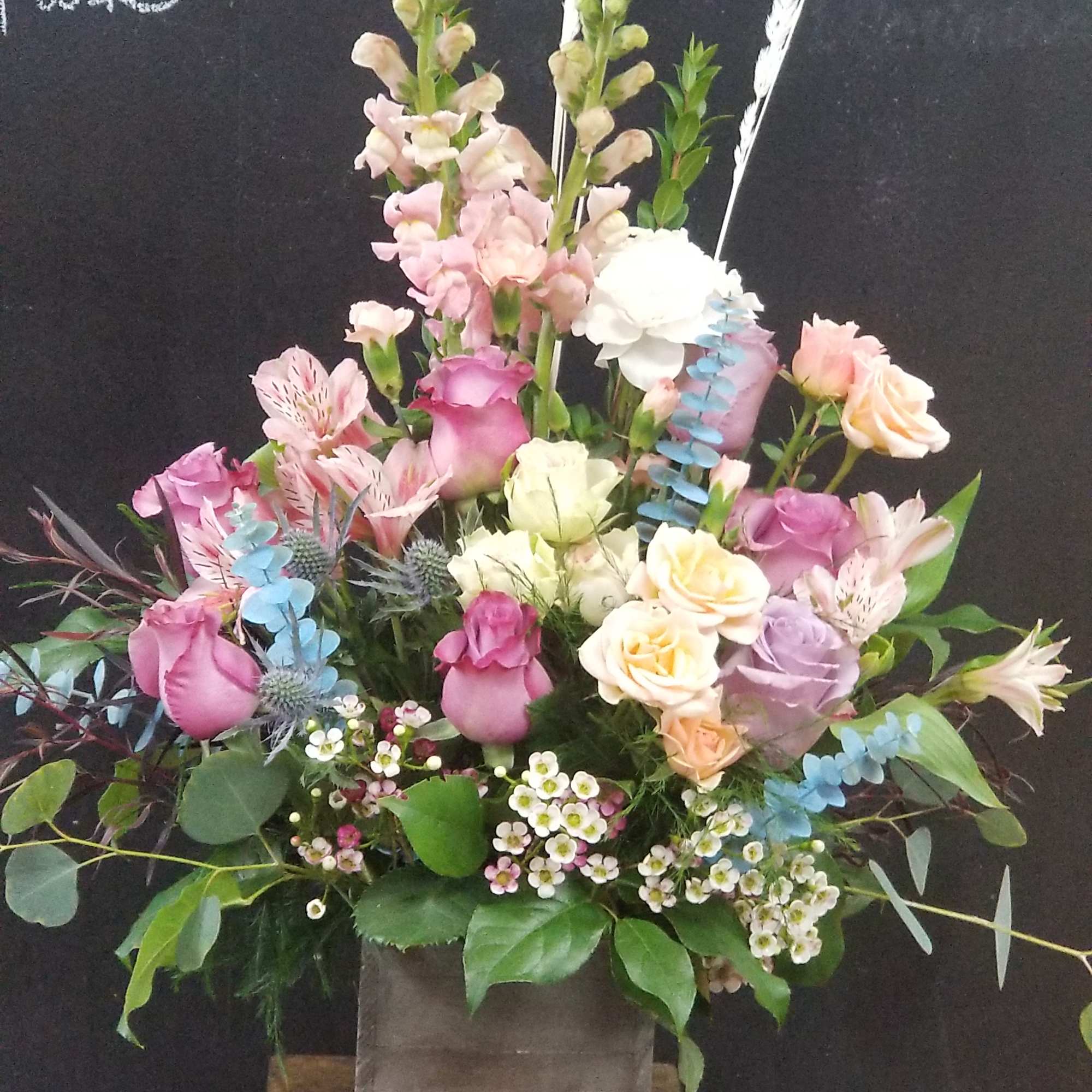 Tall mixed bouquet in a square gray vase with pink and white flowers