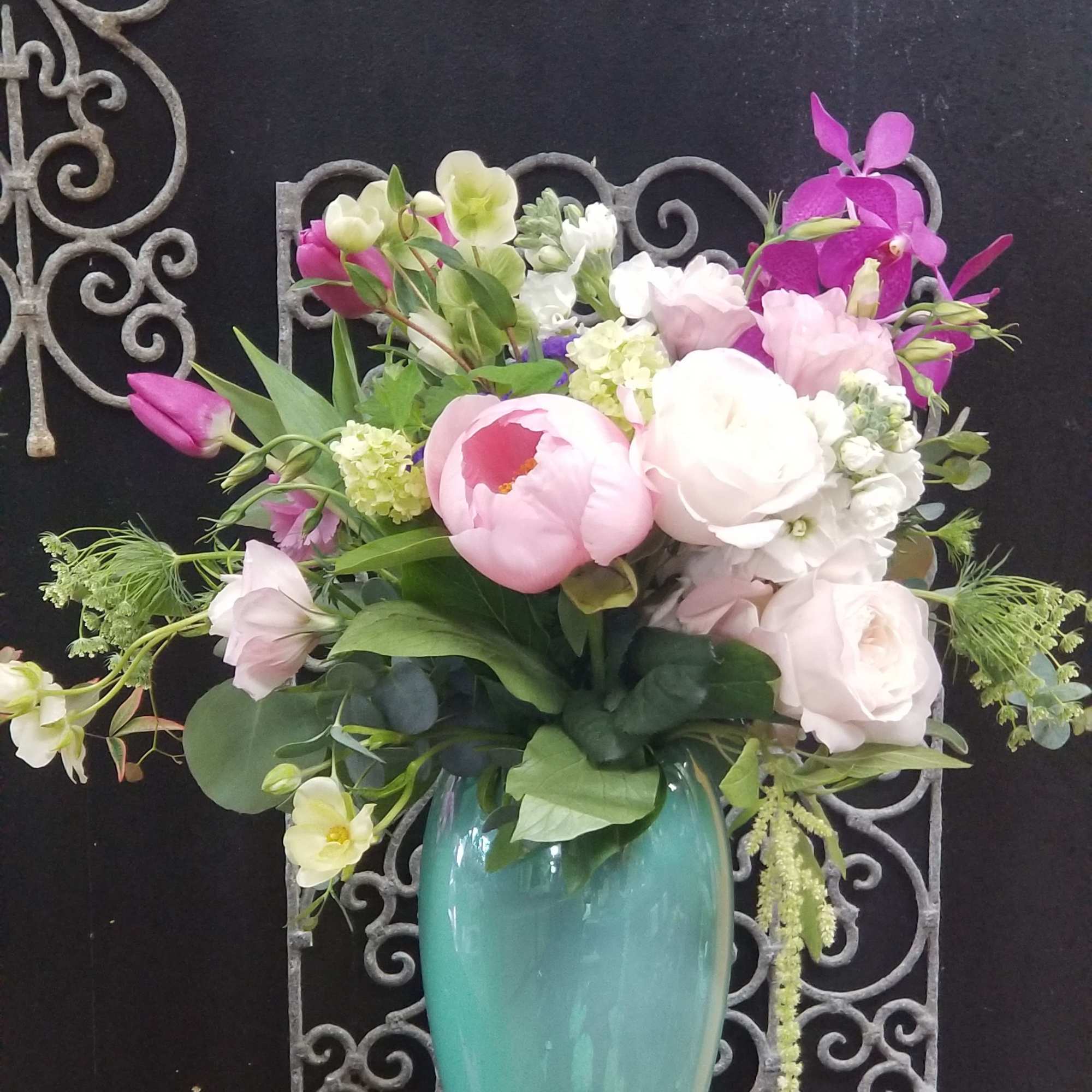 Pink and white floral arrangement in a turquoise vase