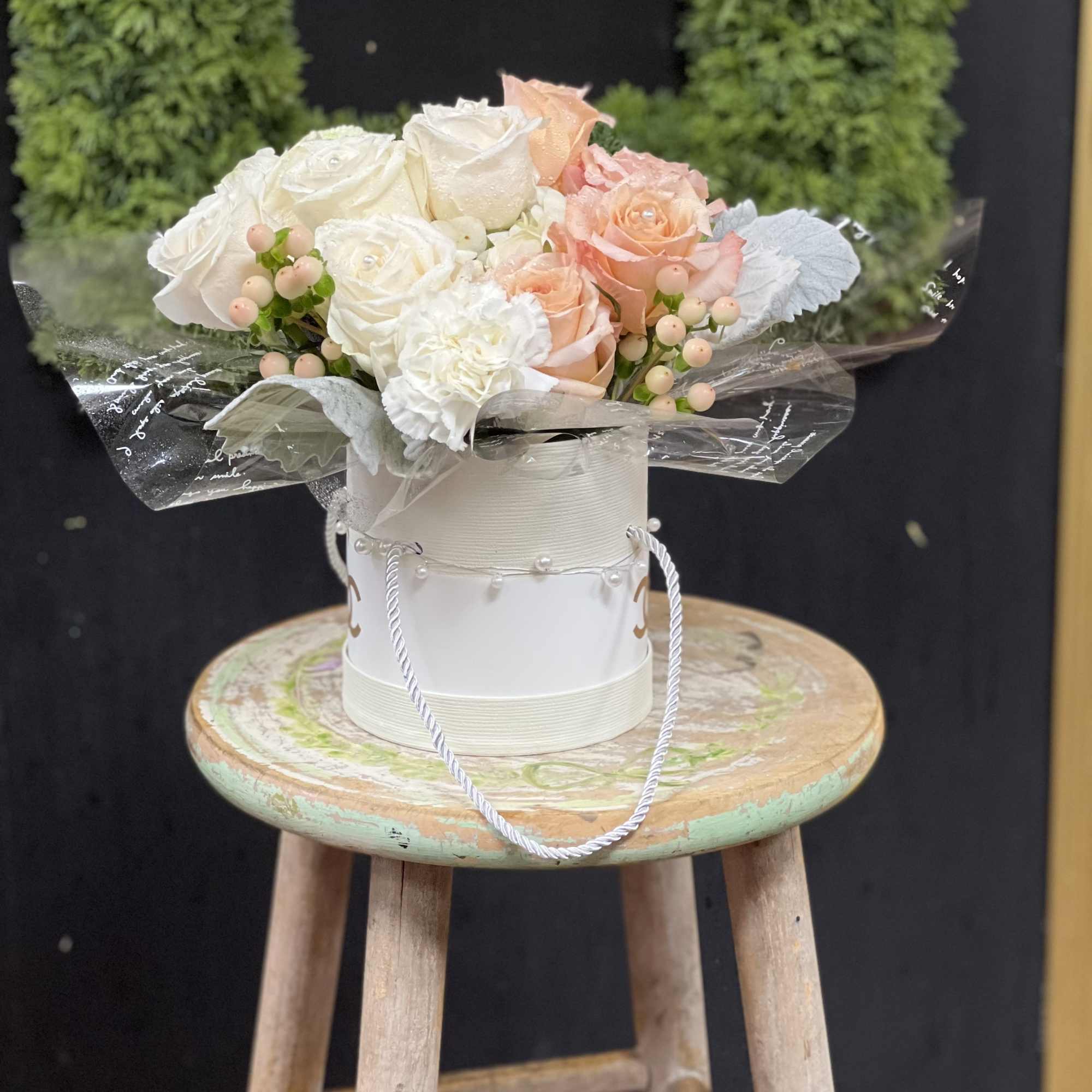 White and peach rose bouquet in a round gift box