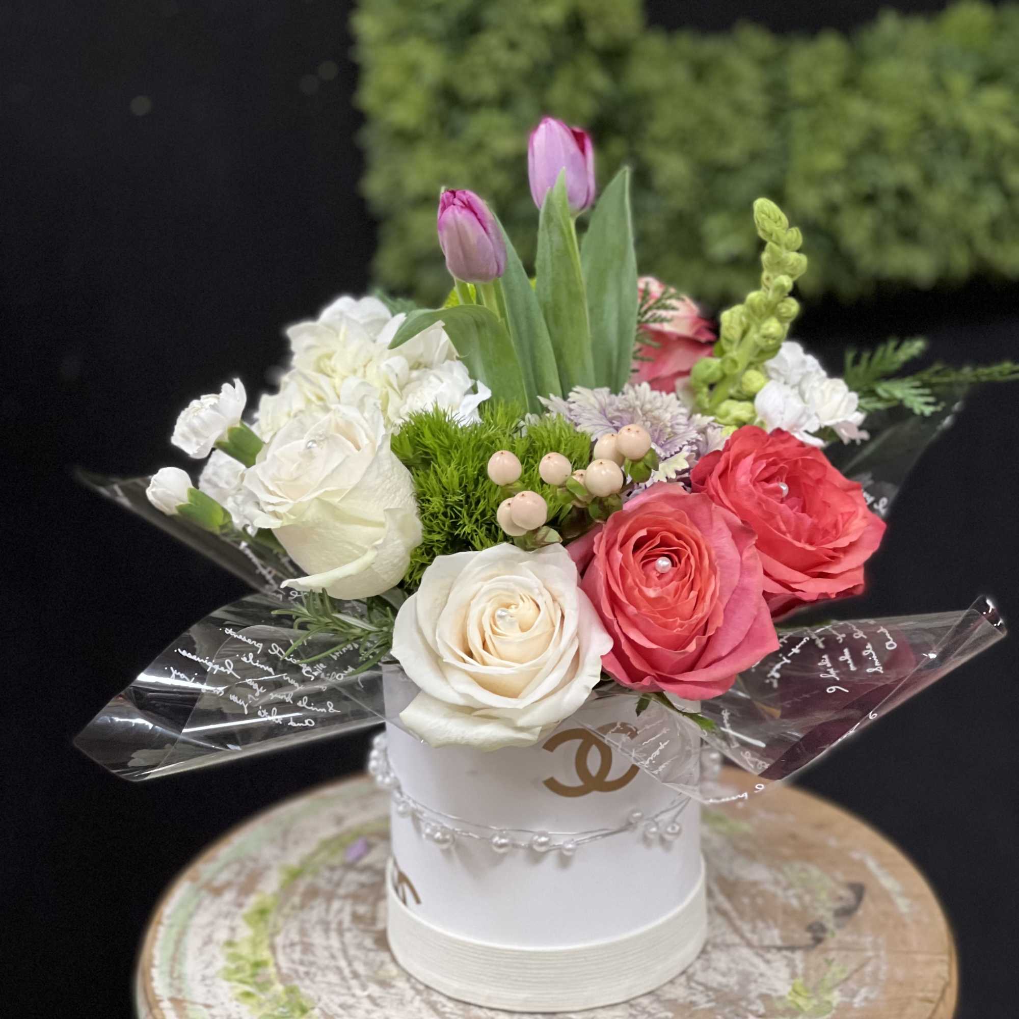 Bouquet of pink and white roses with tulips in a white hatbox
