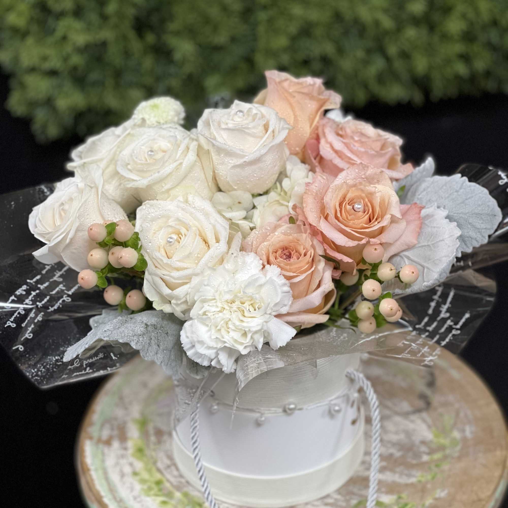 Bouquet of white and blush roses in a white hatbox