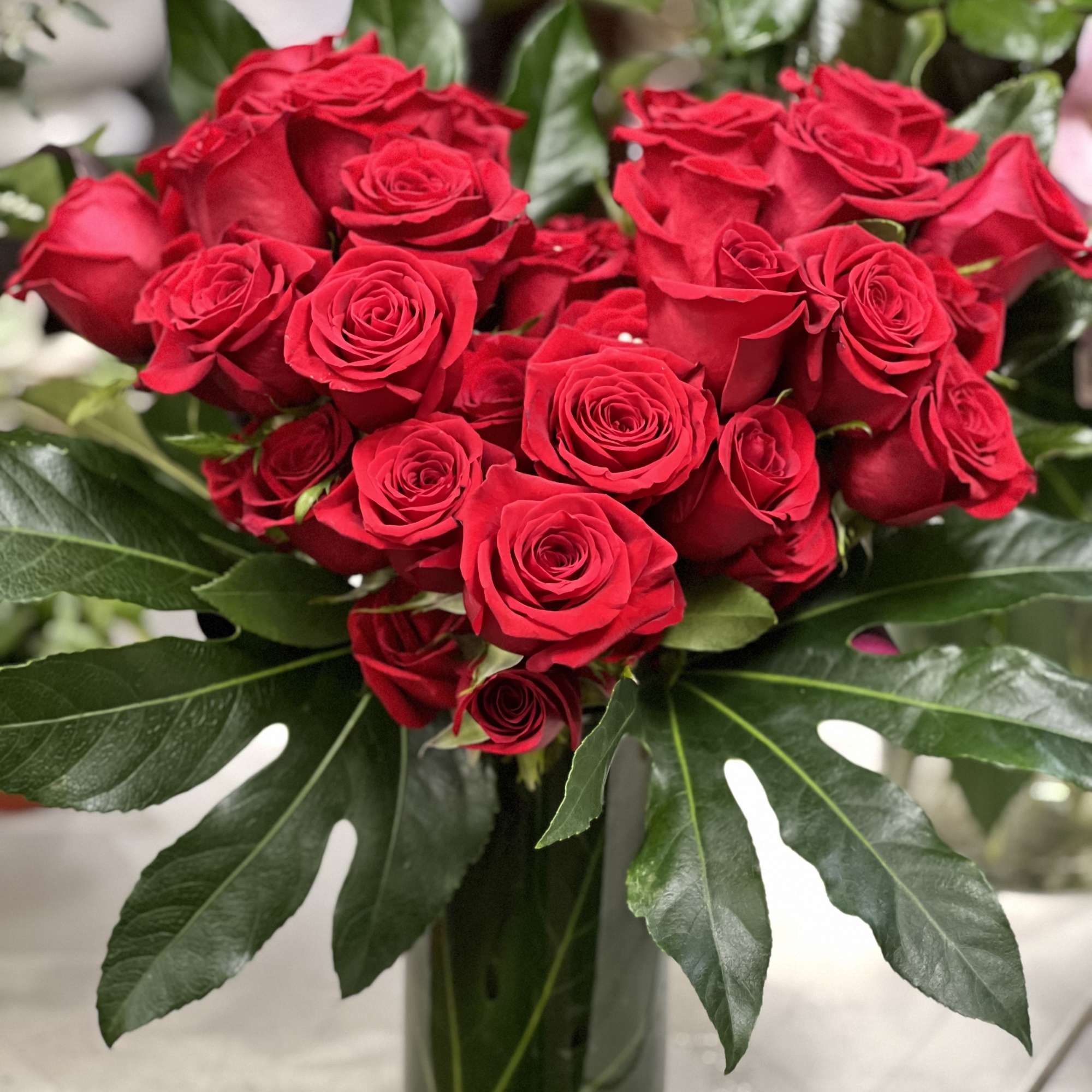 Red roses arranged in a clear glass vase