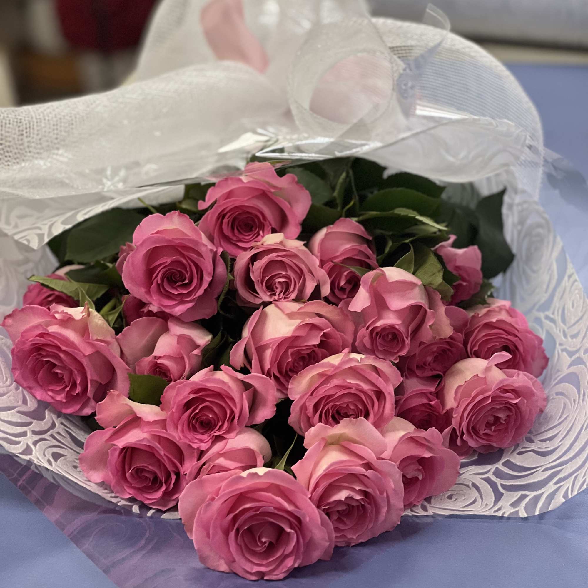 Bouquet of pink roses wrapped in white paper