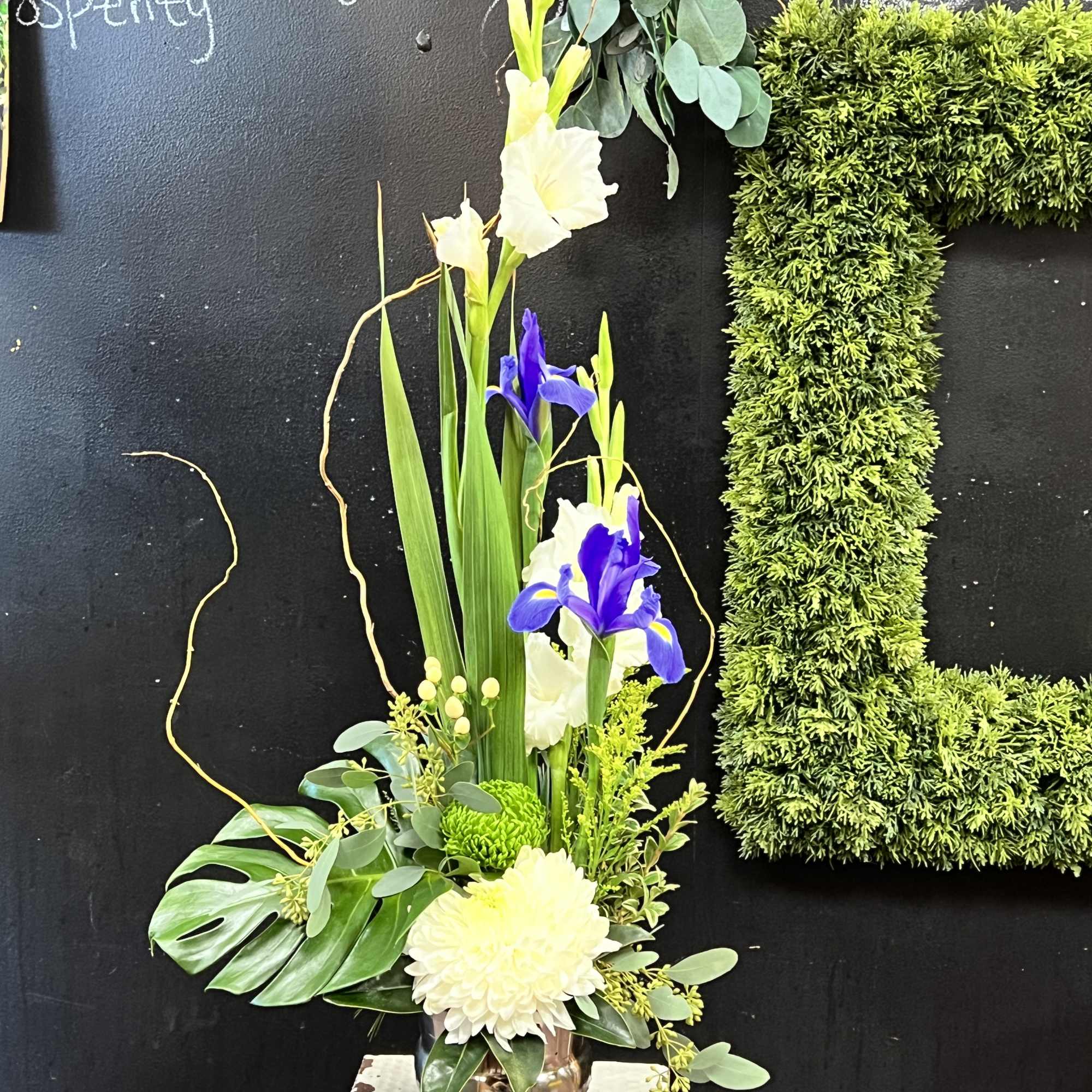 Tall floral arrangement with white and purple irises in a vase