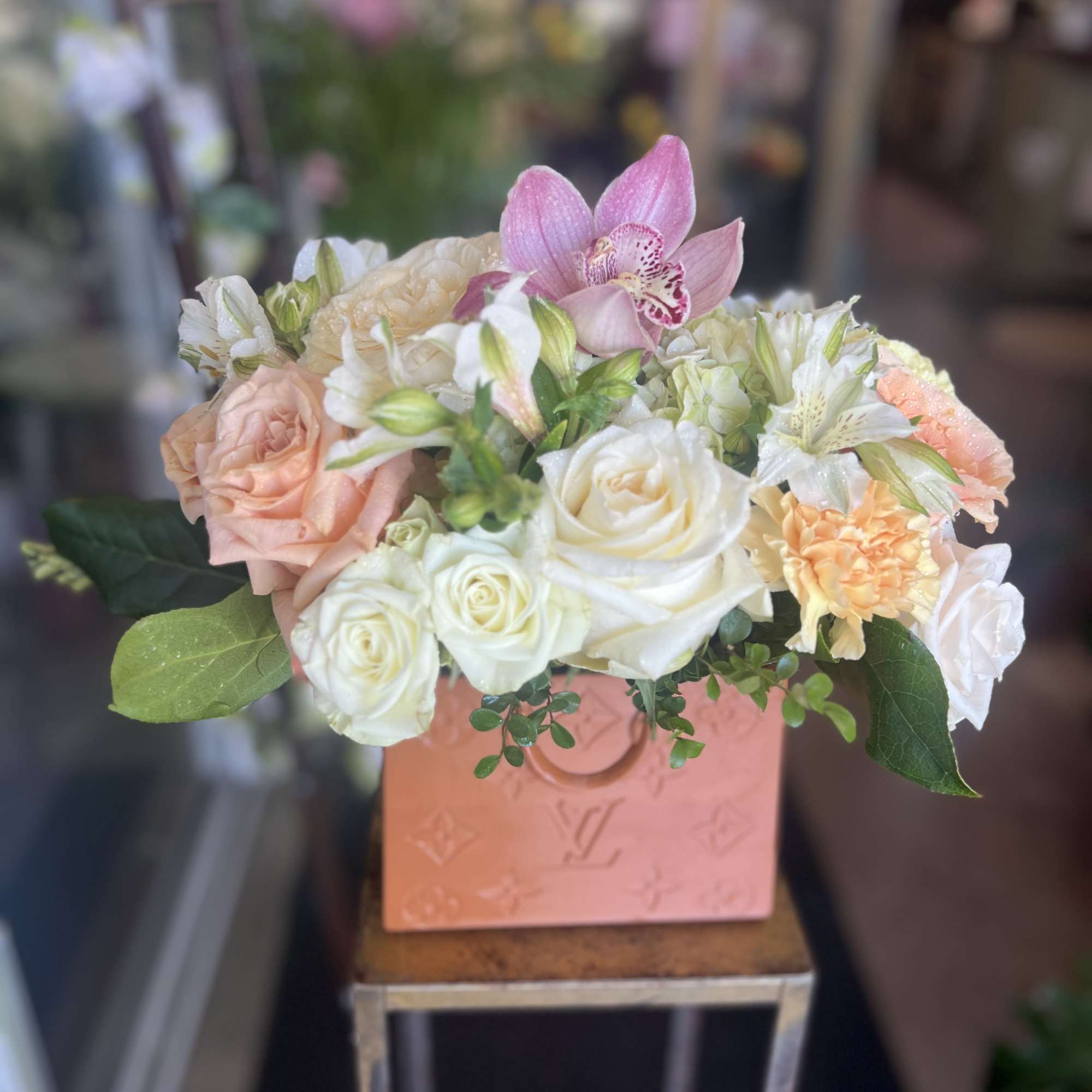 Pink and white flower arrangement in a peach box