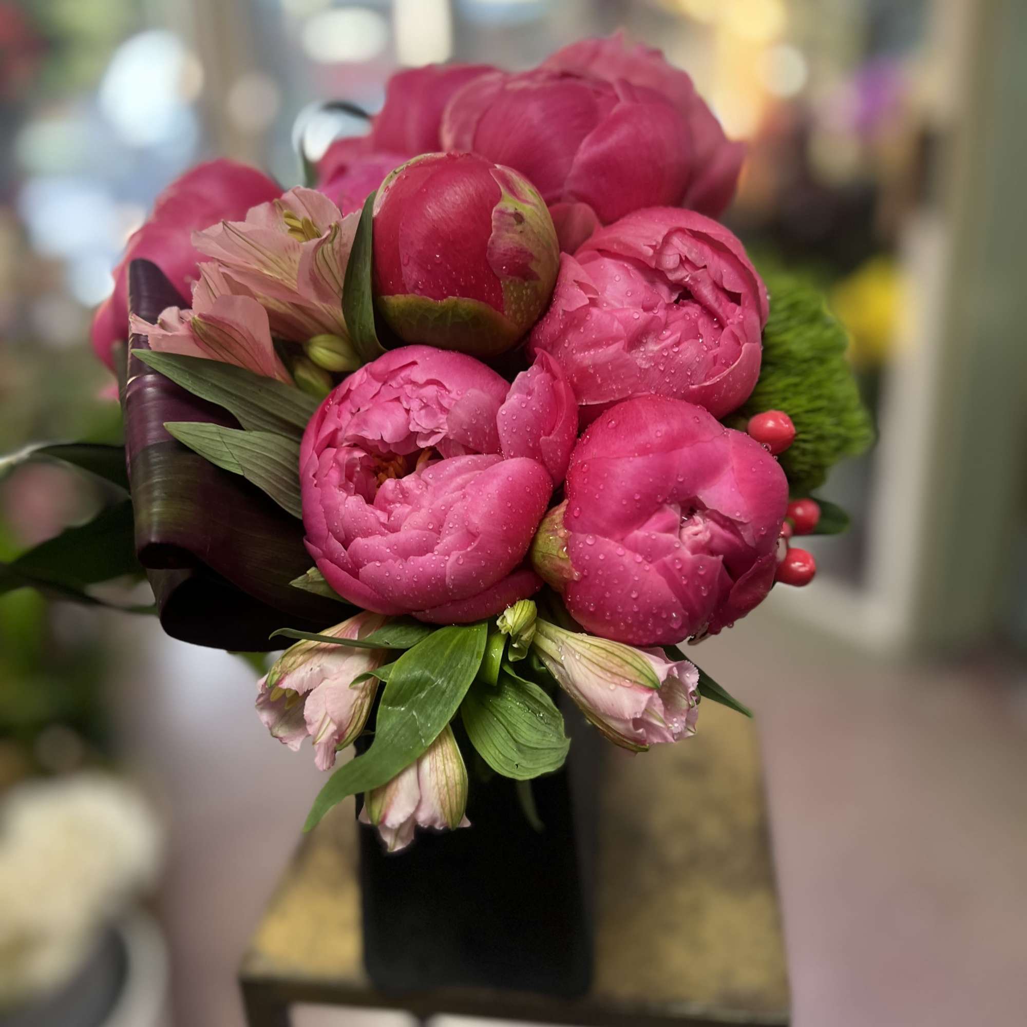 Pink peony bouquet with small pale pink blooms and green accents