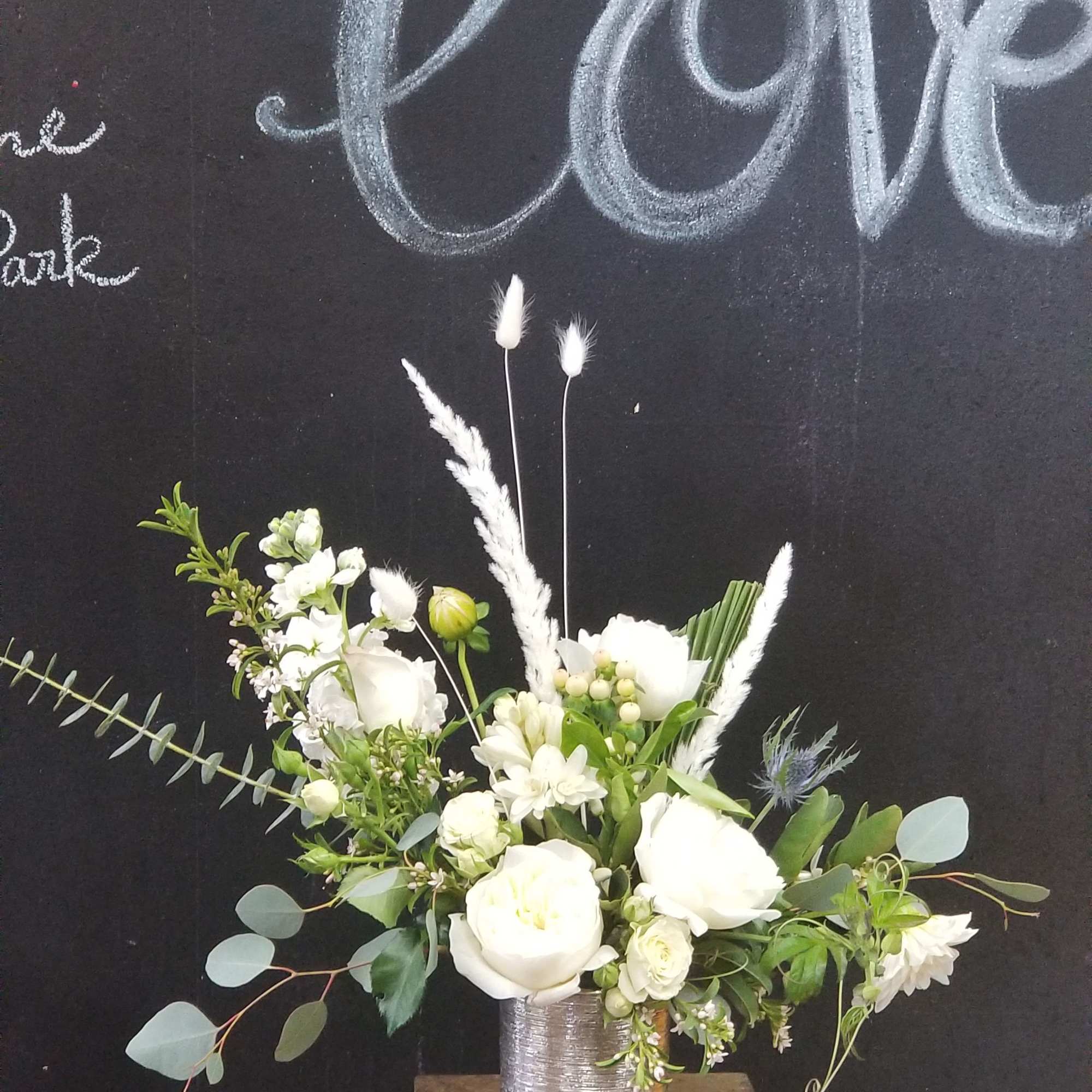 White floral arrangement in a silver vase on a stand