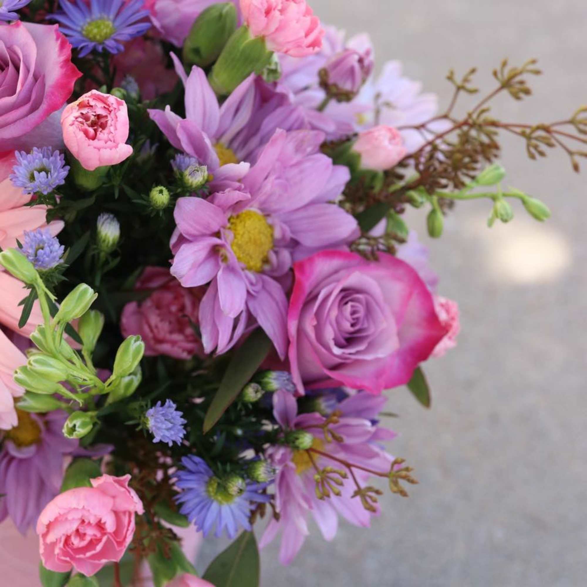 Bouquet of pink and lavender flowers with roses and daisies
