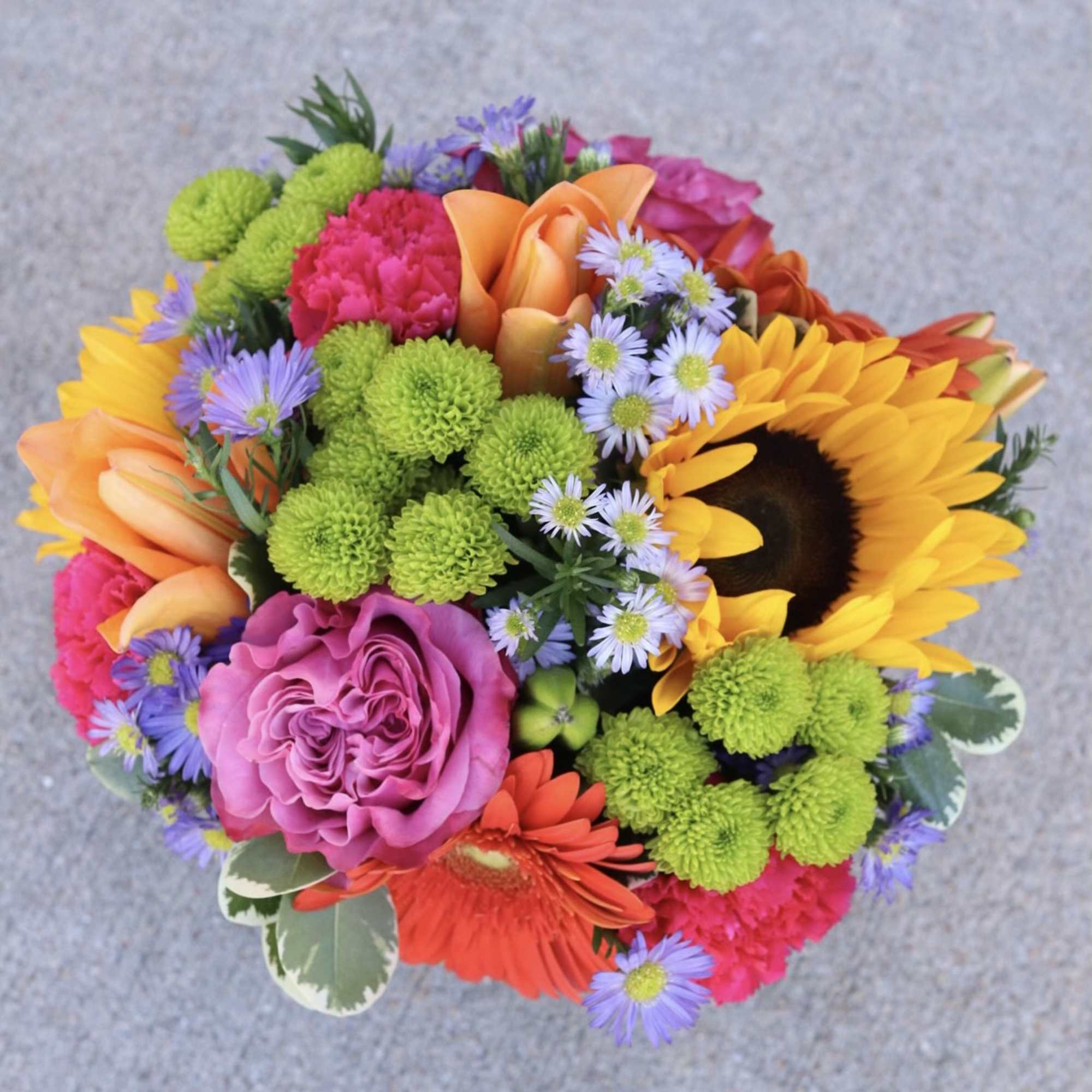 Colorful bouquet with a sunflower, pink rose, and orange calla lilies