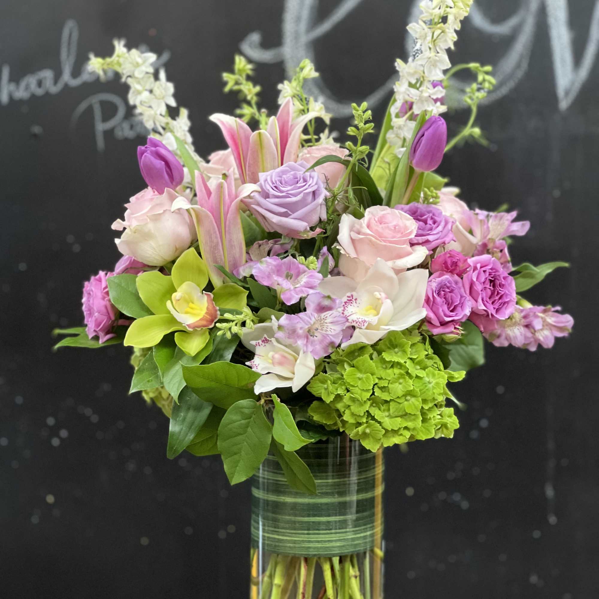 Pink and lavender floral arrangement in a clear glass vase