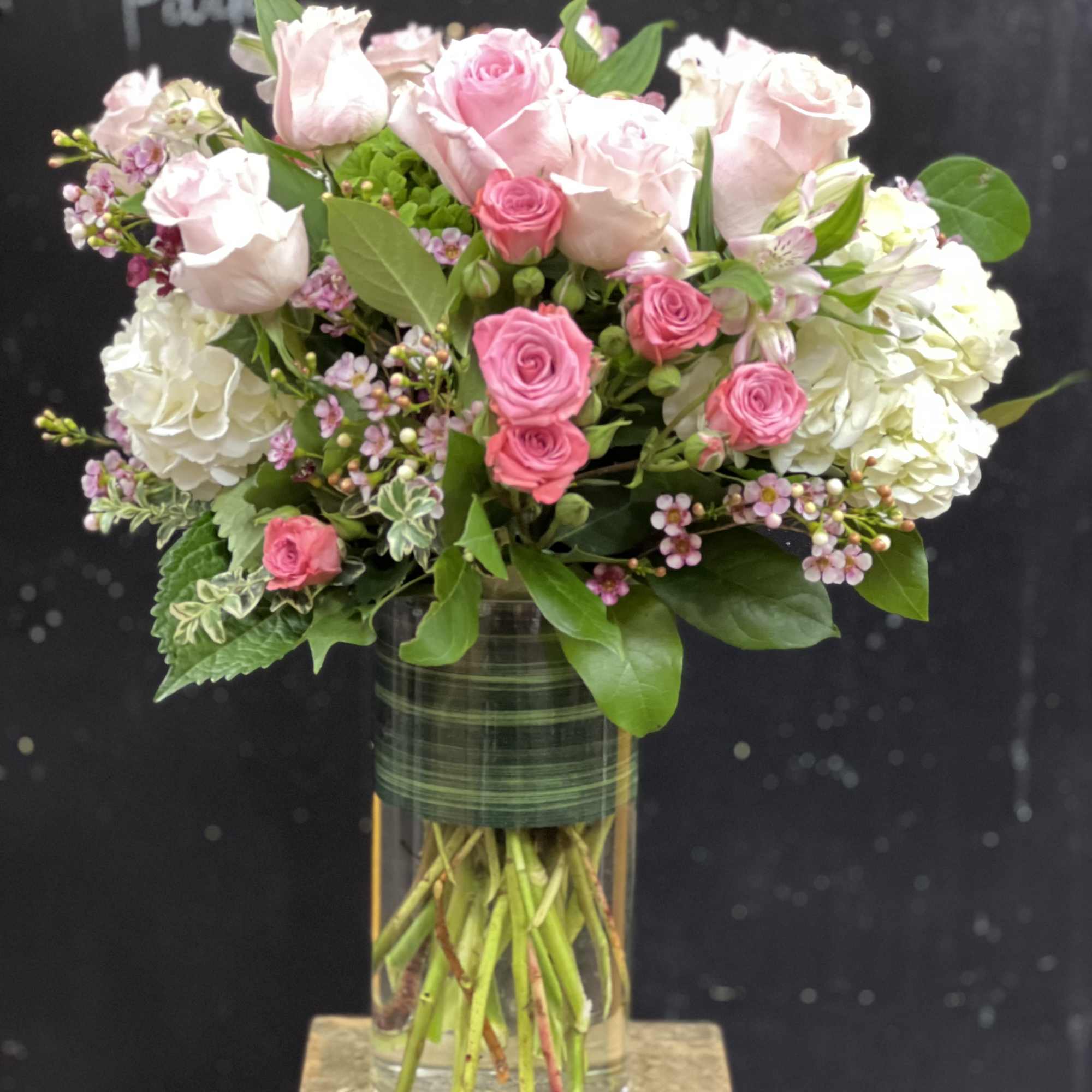 Pink and white roses arranged in a clear glass vase, photo 3 of 5