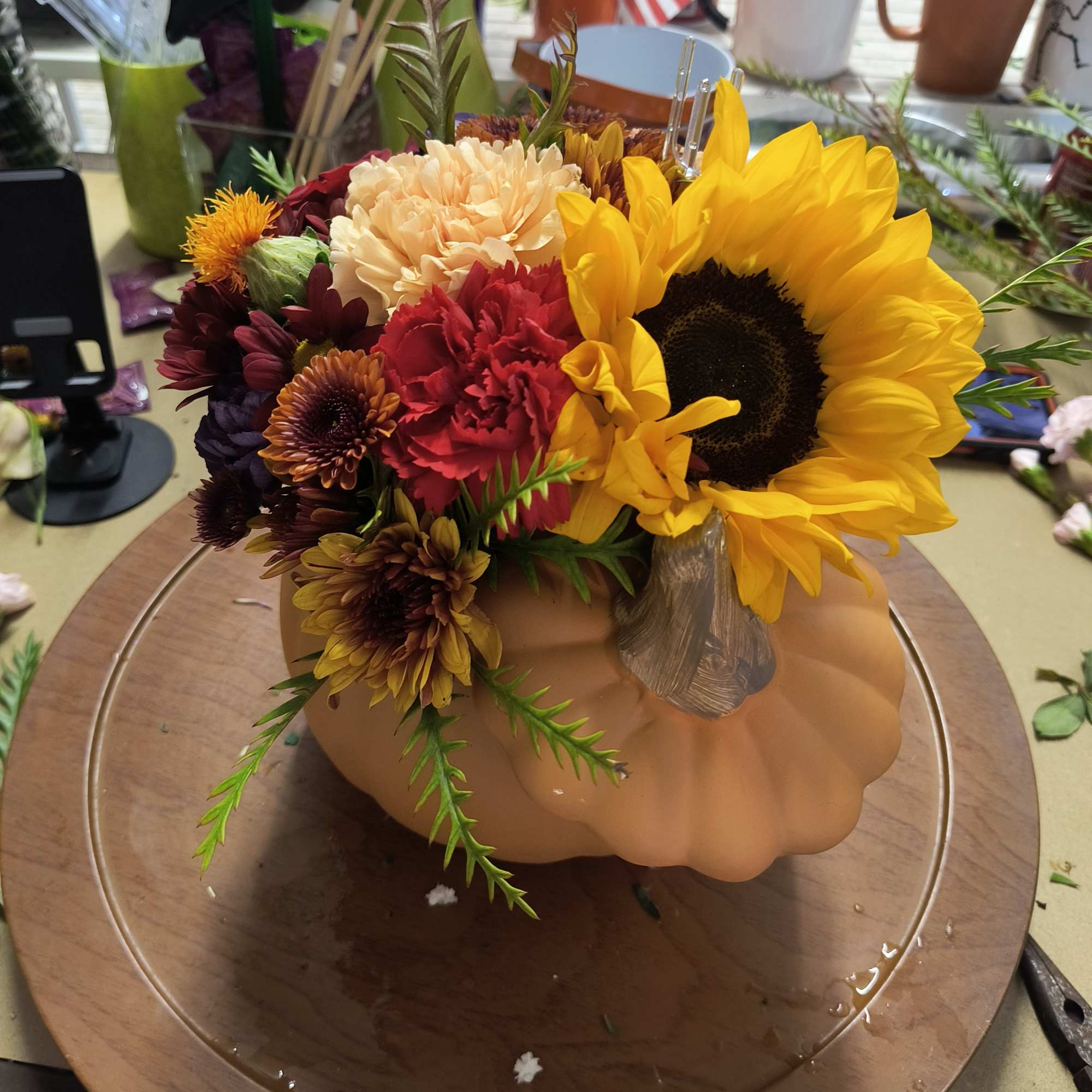 Mixed bouquet in a pumpkin-shaped container with a large sunflower