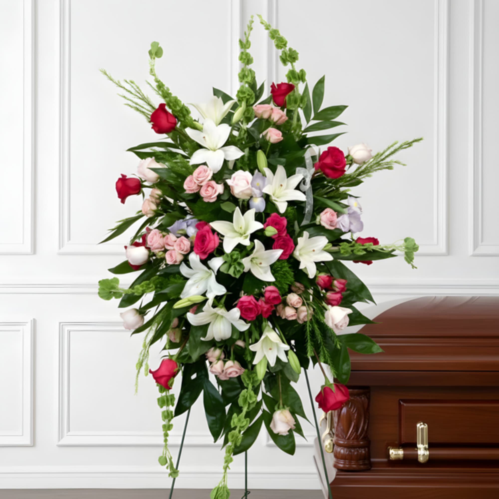 Standing floral spray with white lilies, pink roses, and red roses