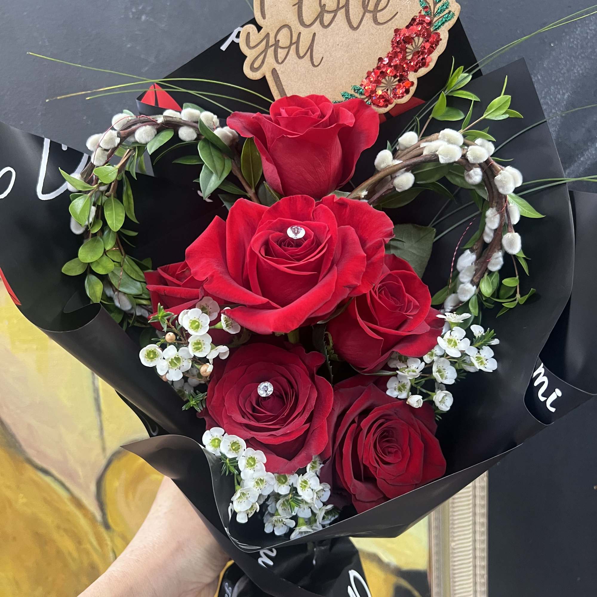 Bouquet of red roses with a heart-shaped "I love you" topper